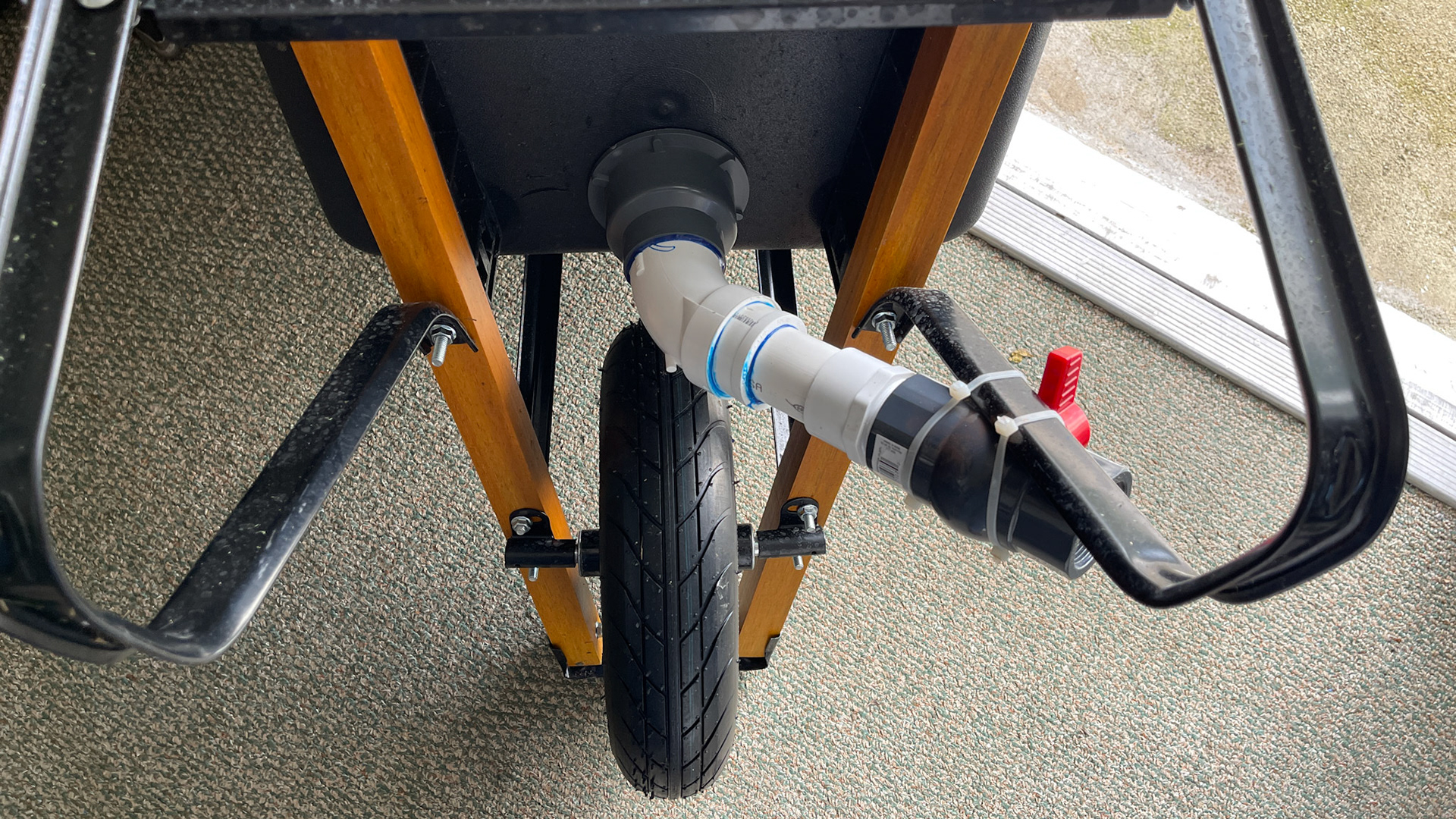 The piping below a 3 inch shower drain placed in the bottom of this wheel barrow.