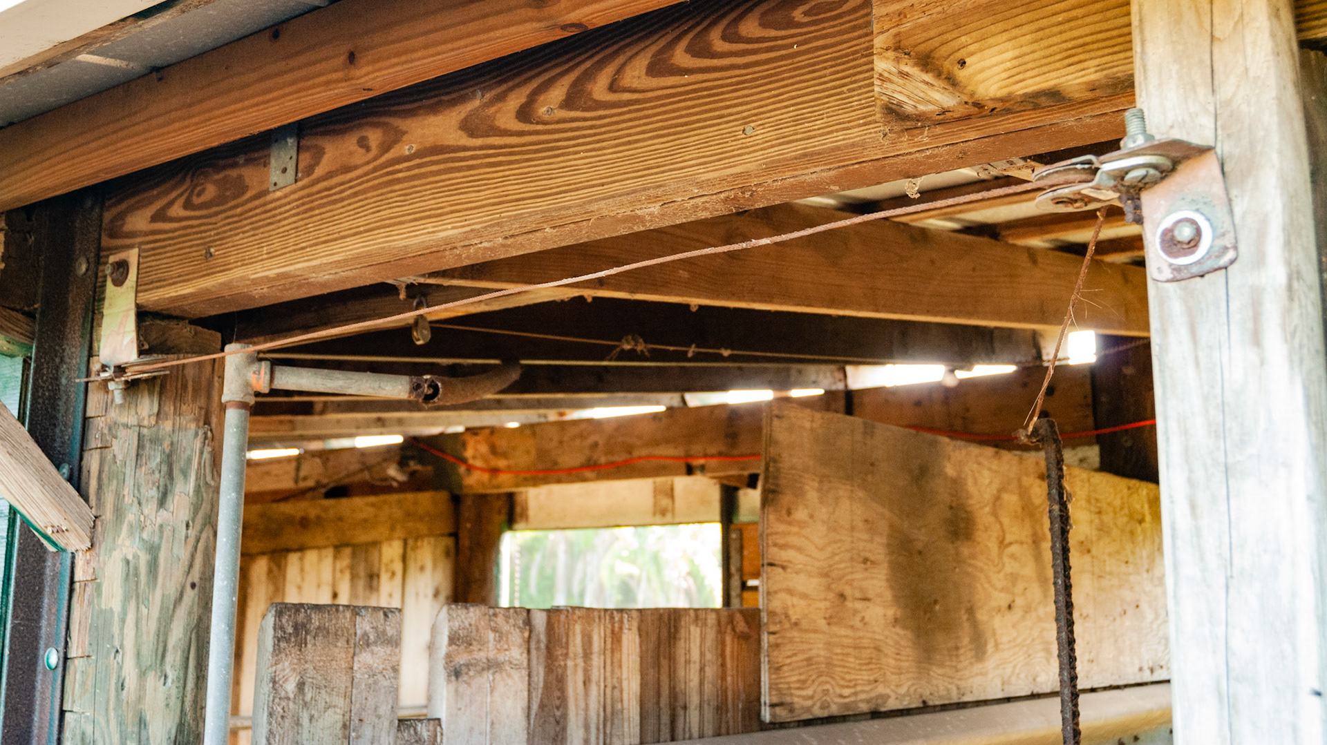 This is part of a complex arrangement of cables, pulleys, levers and springs that allowed someone on the front side of the stall to open or close the back door of the stall.