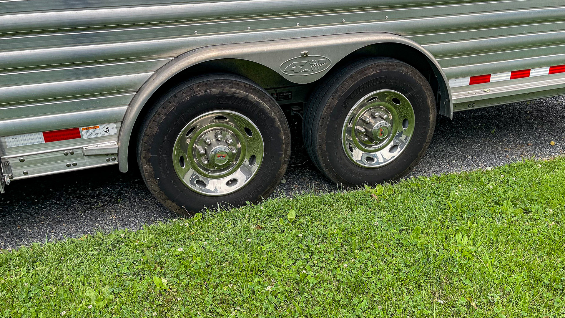 A gooseneck trailer on a pickup truck. The double axle supports the trailer’s weight and adds an extra set of brakes, while the single wheel per axle increases the available floor space for the horses to stand.
