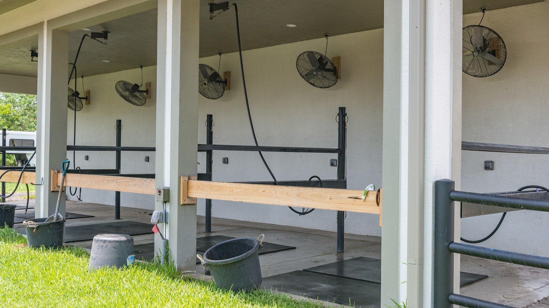 A 5 bay wash area at a 100 horse barn in FL. Note the fan for each stall and the overhead hoses