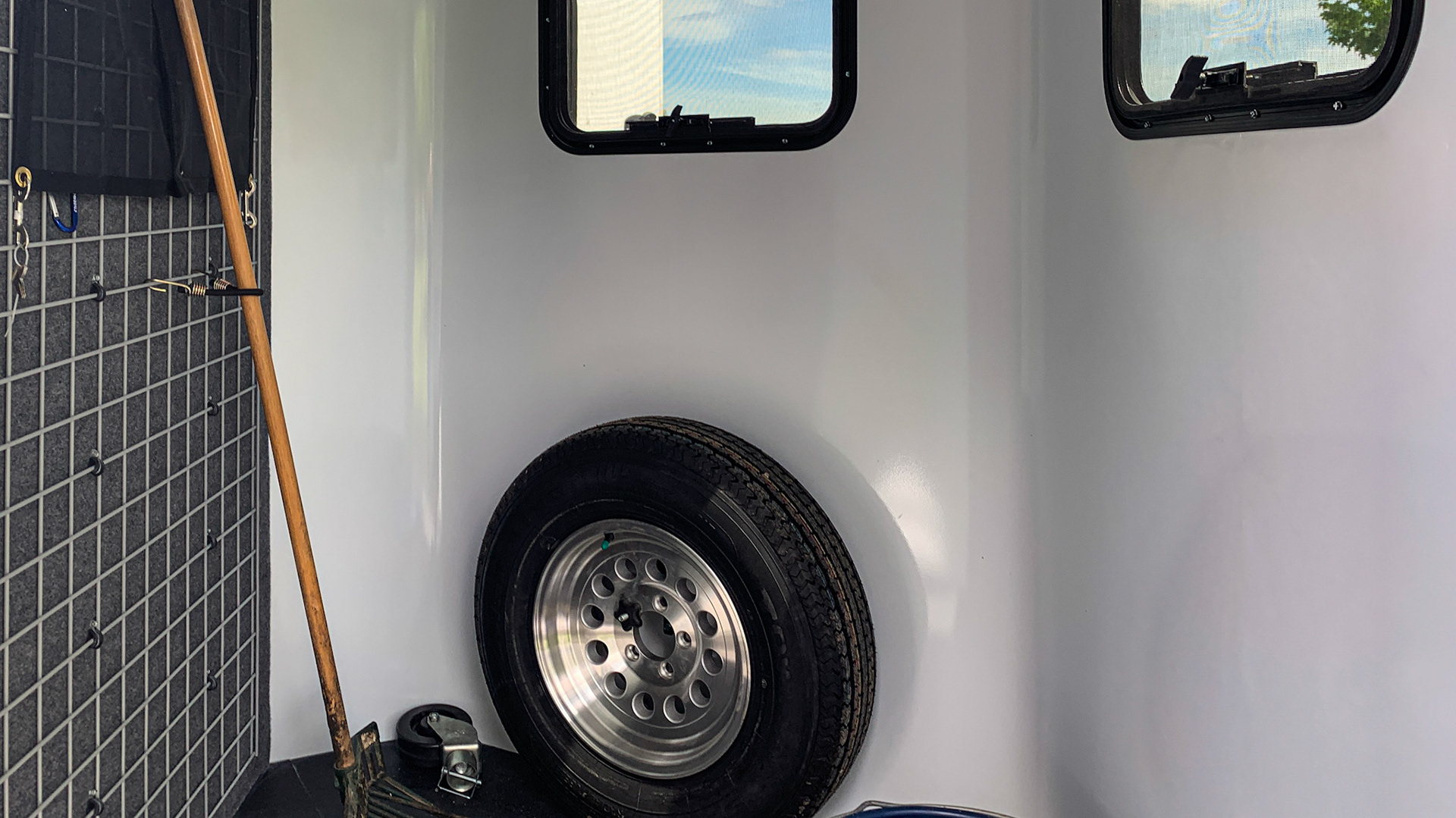 Spar tire, a water bucker, a pitch fork and other equipment can be stored in the nose of this trailer.  Note the pitch fork is attached to the grate to secure it for traveling.