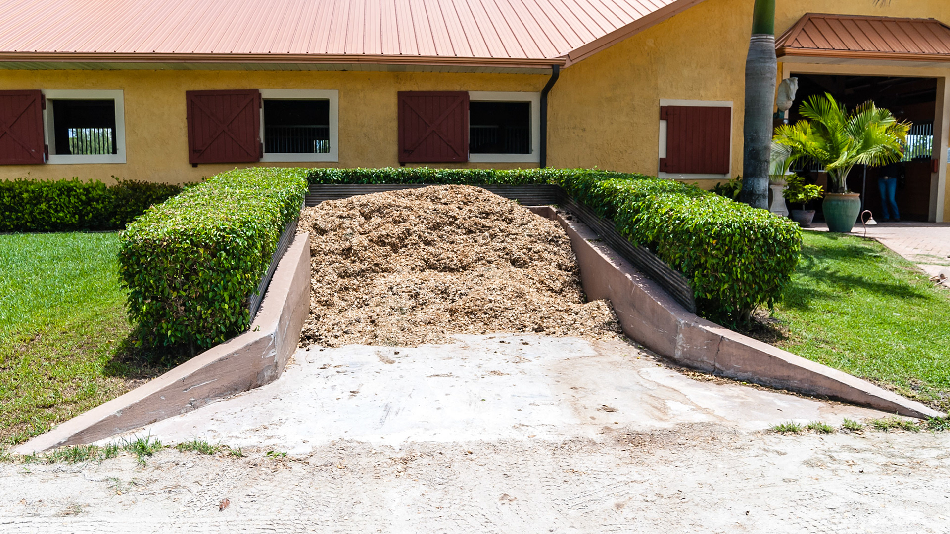 Cement walls and floor to contain waste for periodic scooping.
