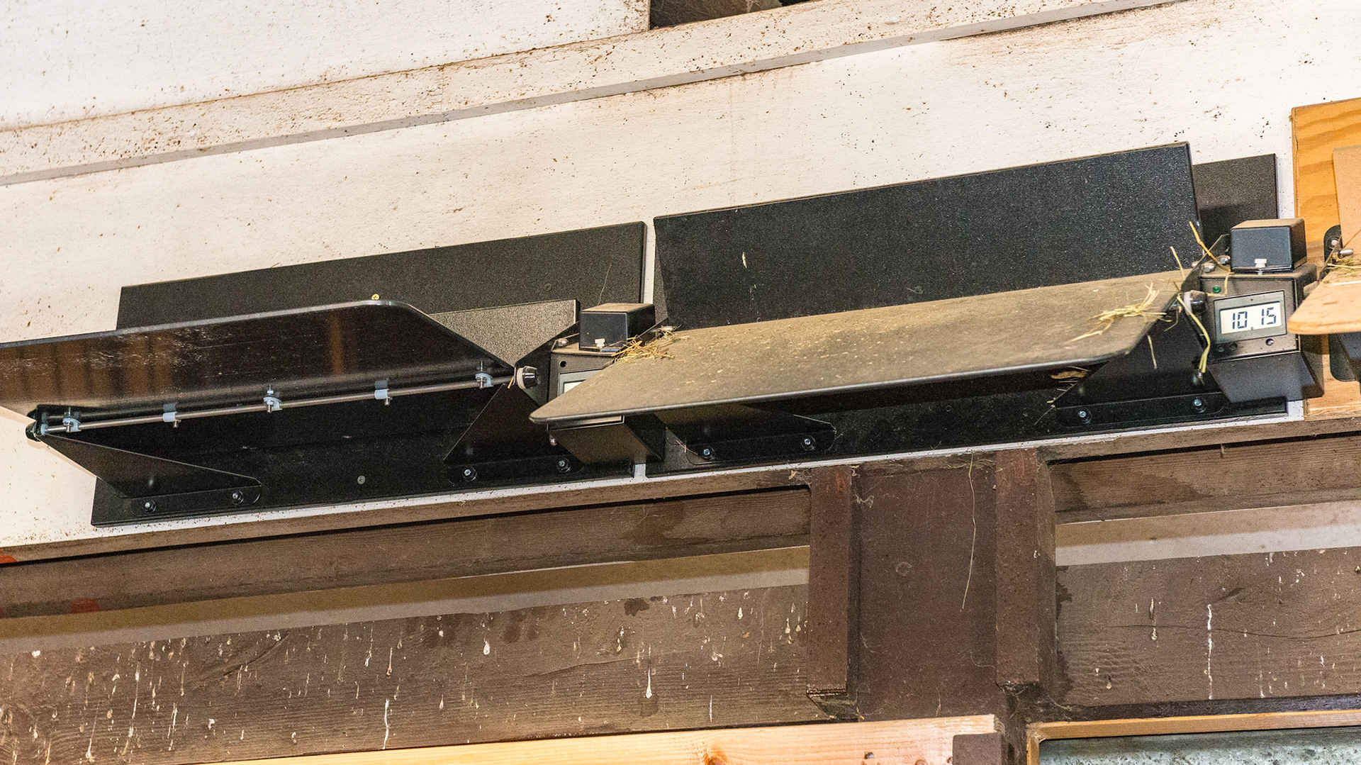 Hay feeders on a timing mechanism delivers 2 pounds of hay three times a night. They are loaded by lifting via pitchfork. the timer activates a solenoid releasing a lock. The weight of the hay tilts the tray and the hay falls into the stall.