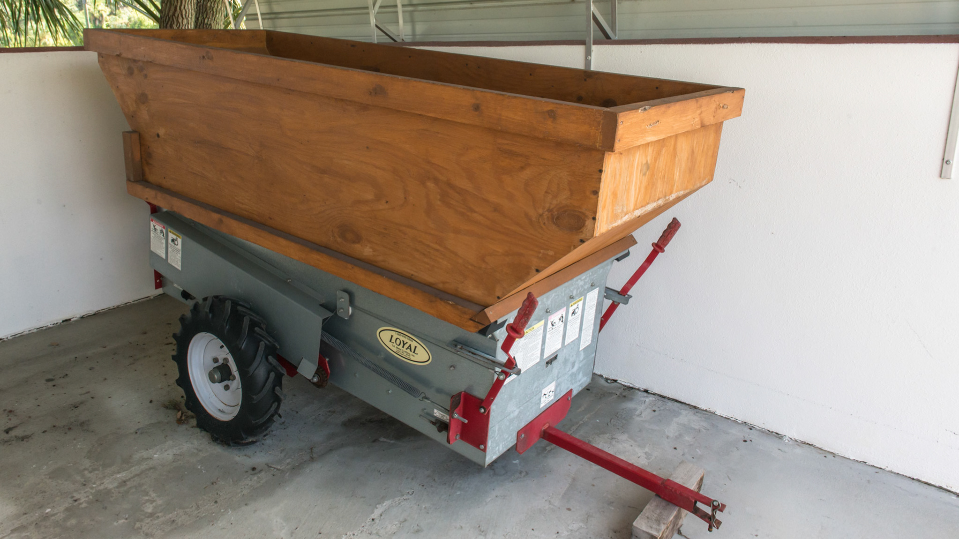 A hand made extension to this small manure spreader doubles its' capacity.  This is a ground driven spreader that any vehicle can pull. One lever operates the blades and the other operates the belt.  Overfilling these machines can cause the load to exceed the ability of the machine to work without breaking.