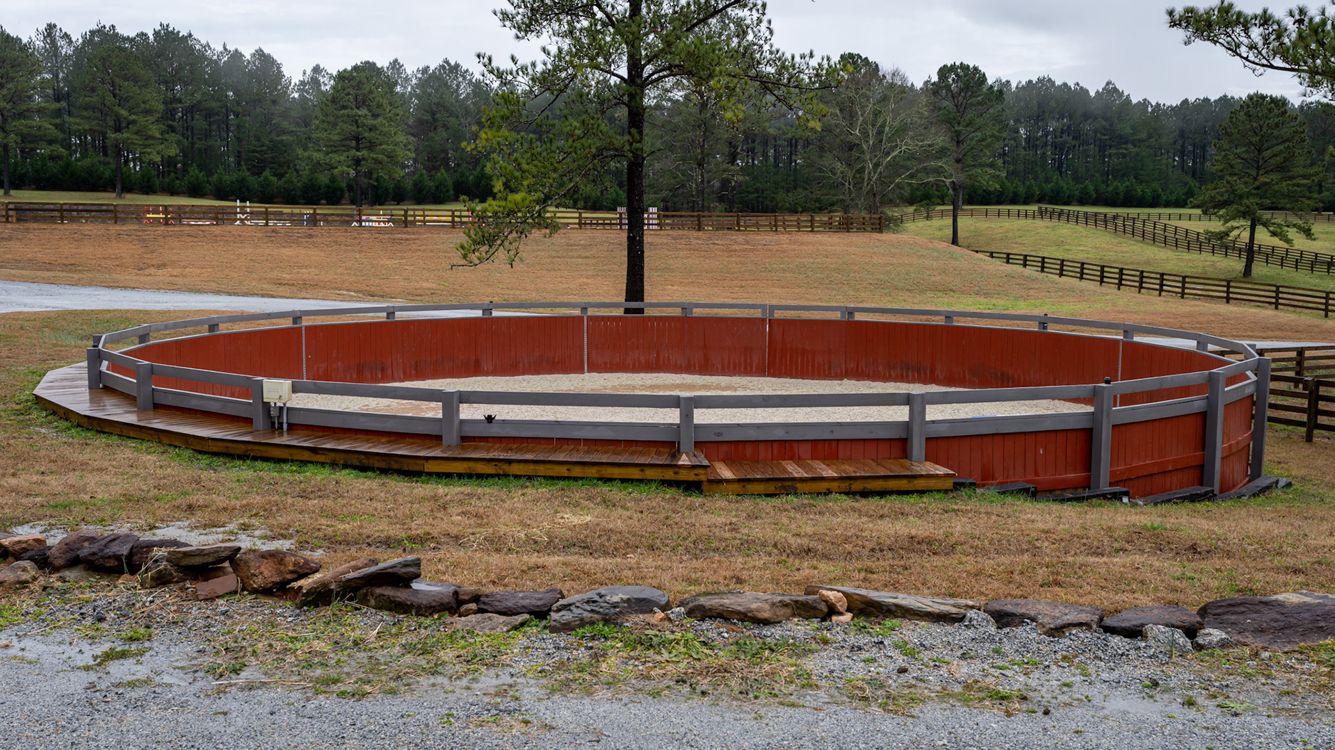 Various views of a round pen built into a hillside.