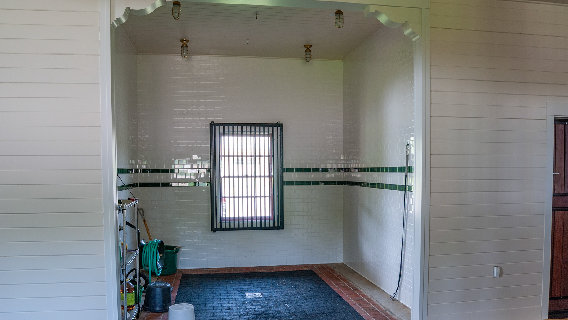 Wash area with inlaid rubber brick flooring and tiled walls.