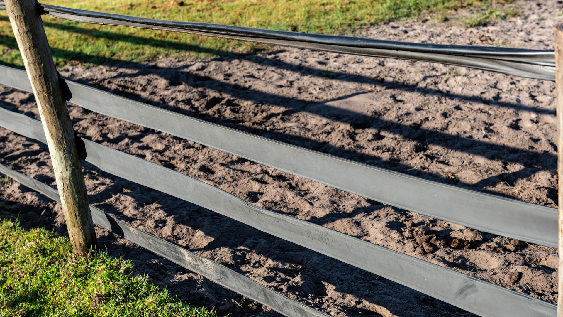 Vinyl fencing - the top strip is collapsed from horses leaning up on it or chewing it and all of them need more tension applied.