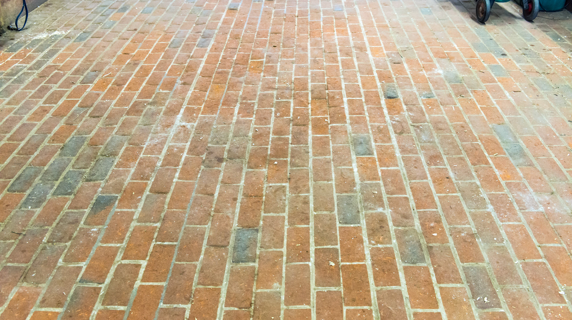 A brick aisle-way in a barn.