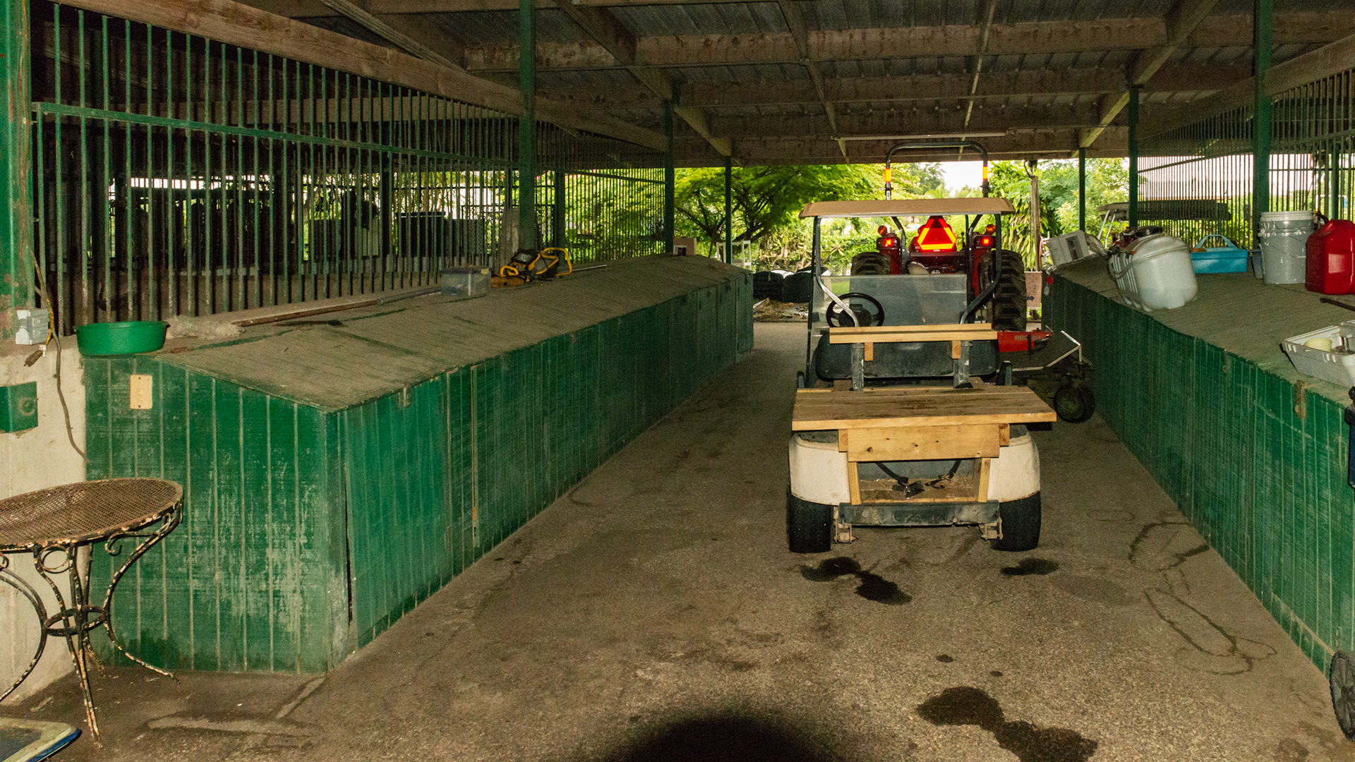 Durable barn structure and well organized and clean feeding area. The cart is used to distribute individual feed buckets.