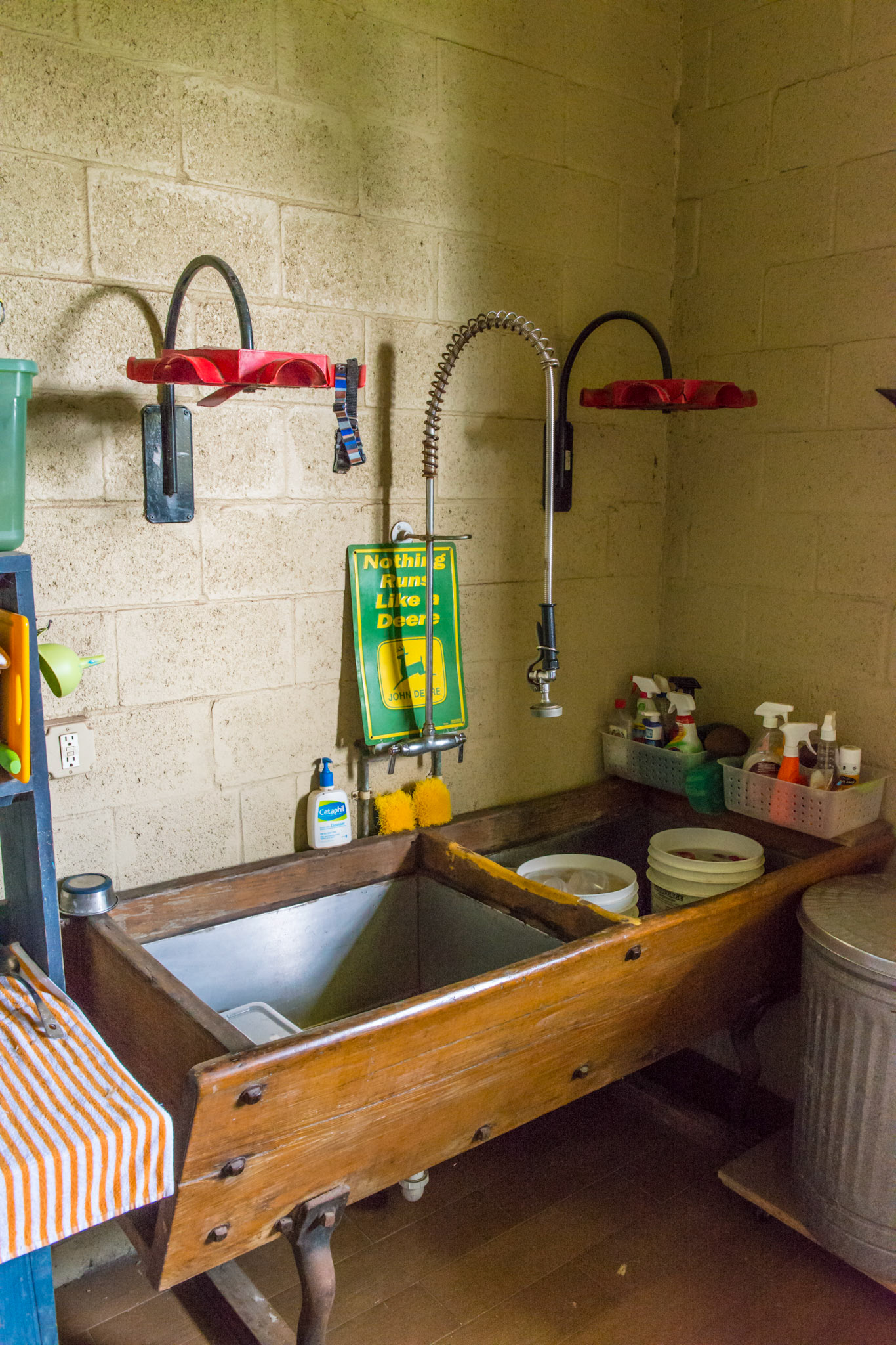 A wooden antique feed trough turned into a sink with stainless steel inserts.