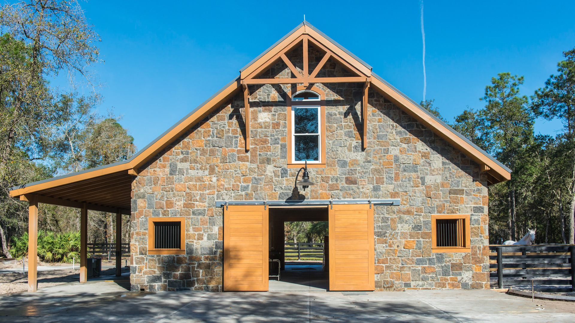 Stone facing and exposed stained wood create a beautiful custom made barn in northern Florida.