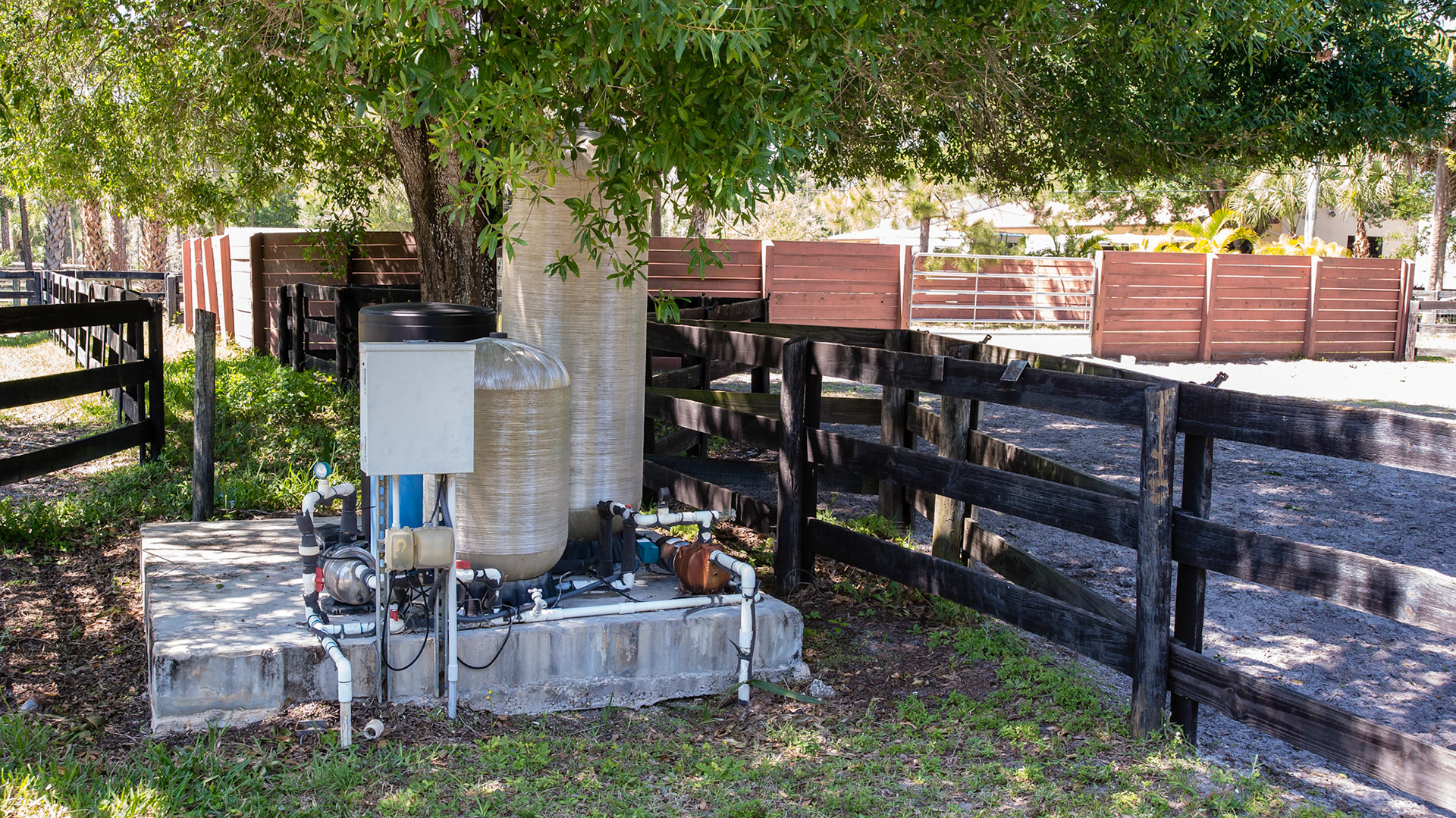 The water pump and water storage located on a cement pad between the paddocks well away from the barn