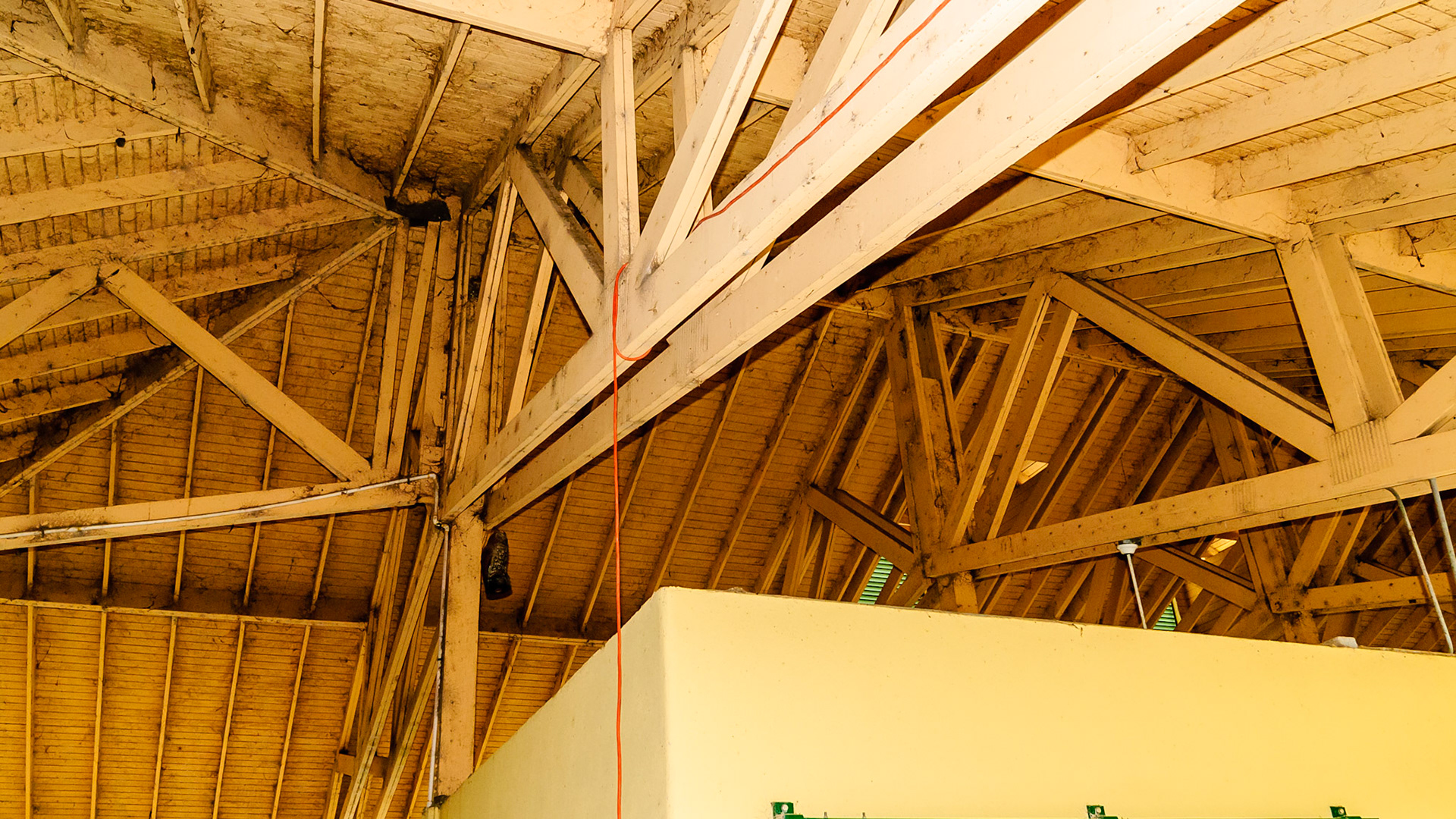 A well built roof for a hurricane prone FL. Note electrical conduit and ventilation through the roof and over the stalls. One problem is cobweb formation and cleaning.
