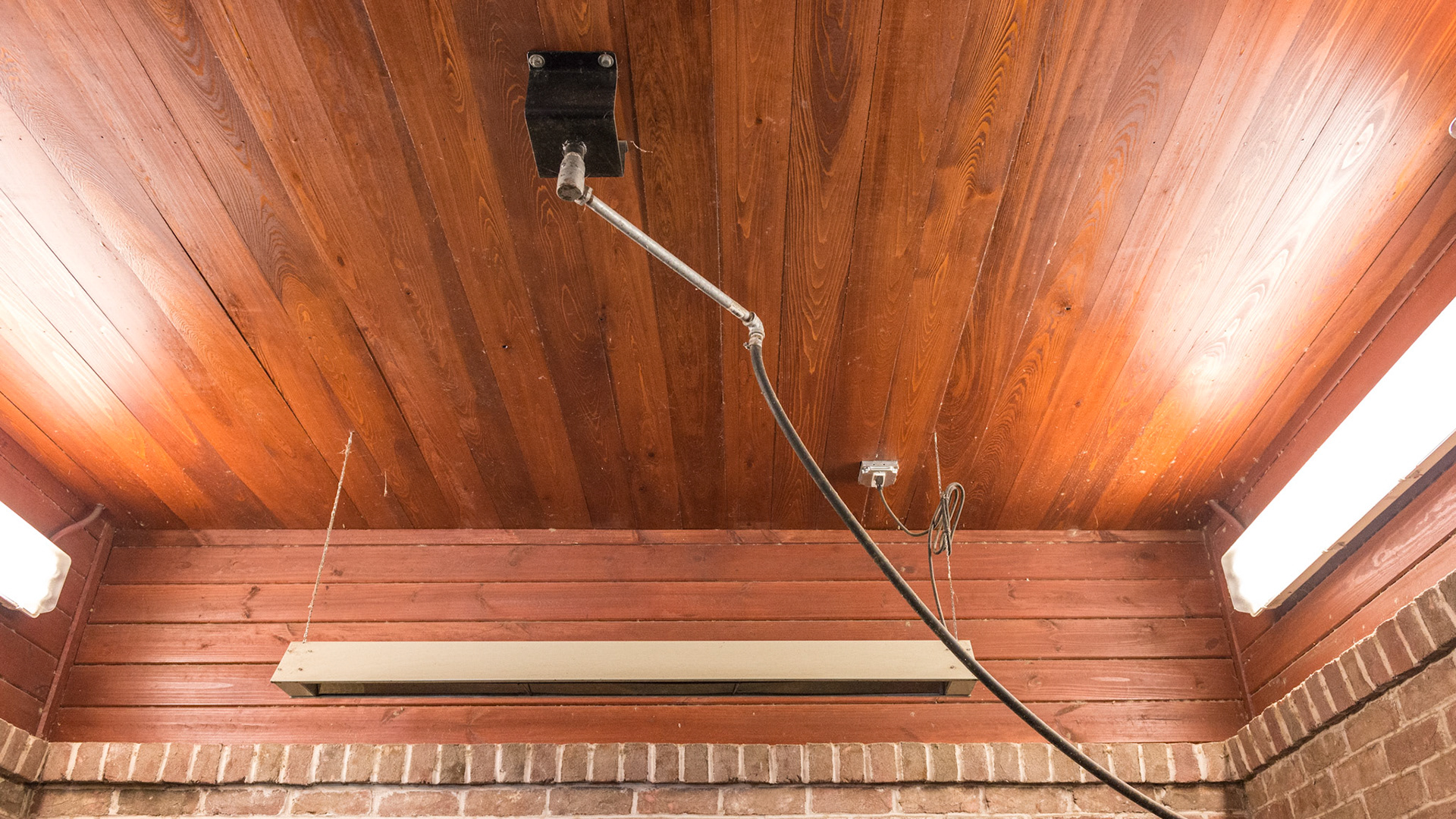 Ceiling mounted rotating water delivery system, electric heater, abundant recessesd lighting, sprinkler head located to the side, and hard wood ceiling well above the horse's head.