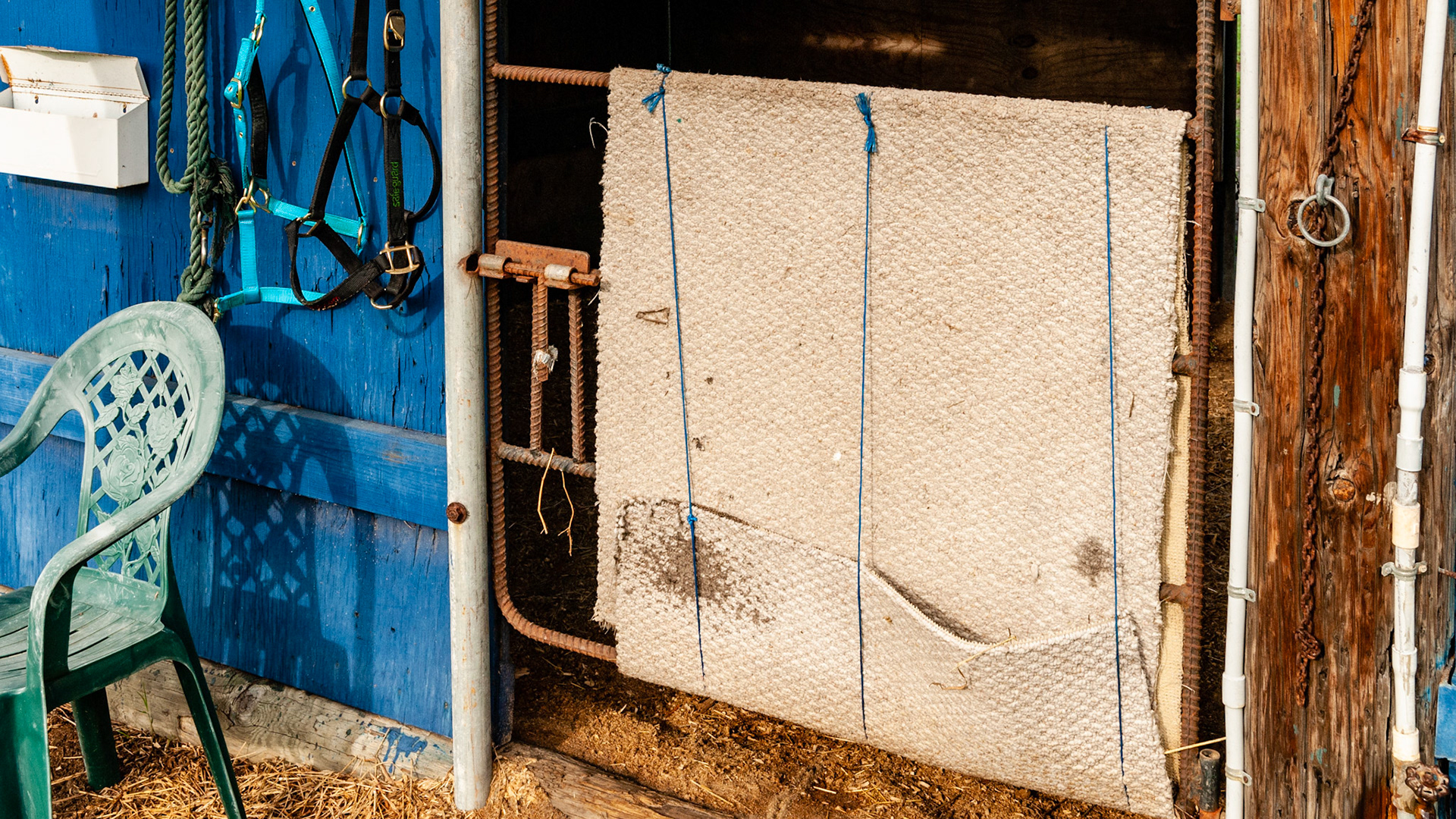 Hand made gate and latch made of welded rebar. This one has a rug tied to it to prevent the horse from stepping through the gate.