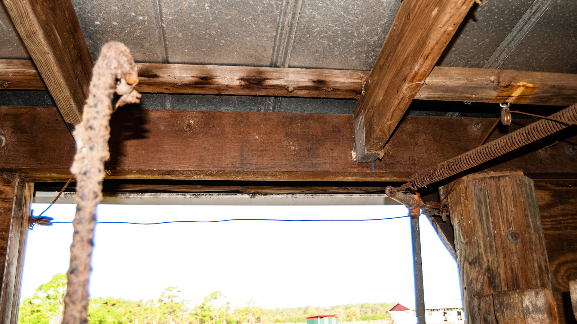 This is part of a complex arrangement of cables, pulleys, levers and springs that allowed someone on the front side of the stall to open or close the back door of the stall.