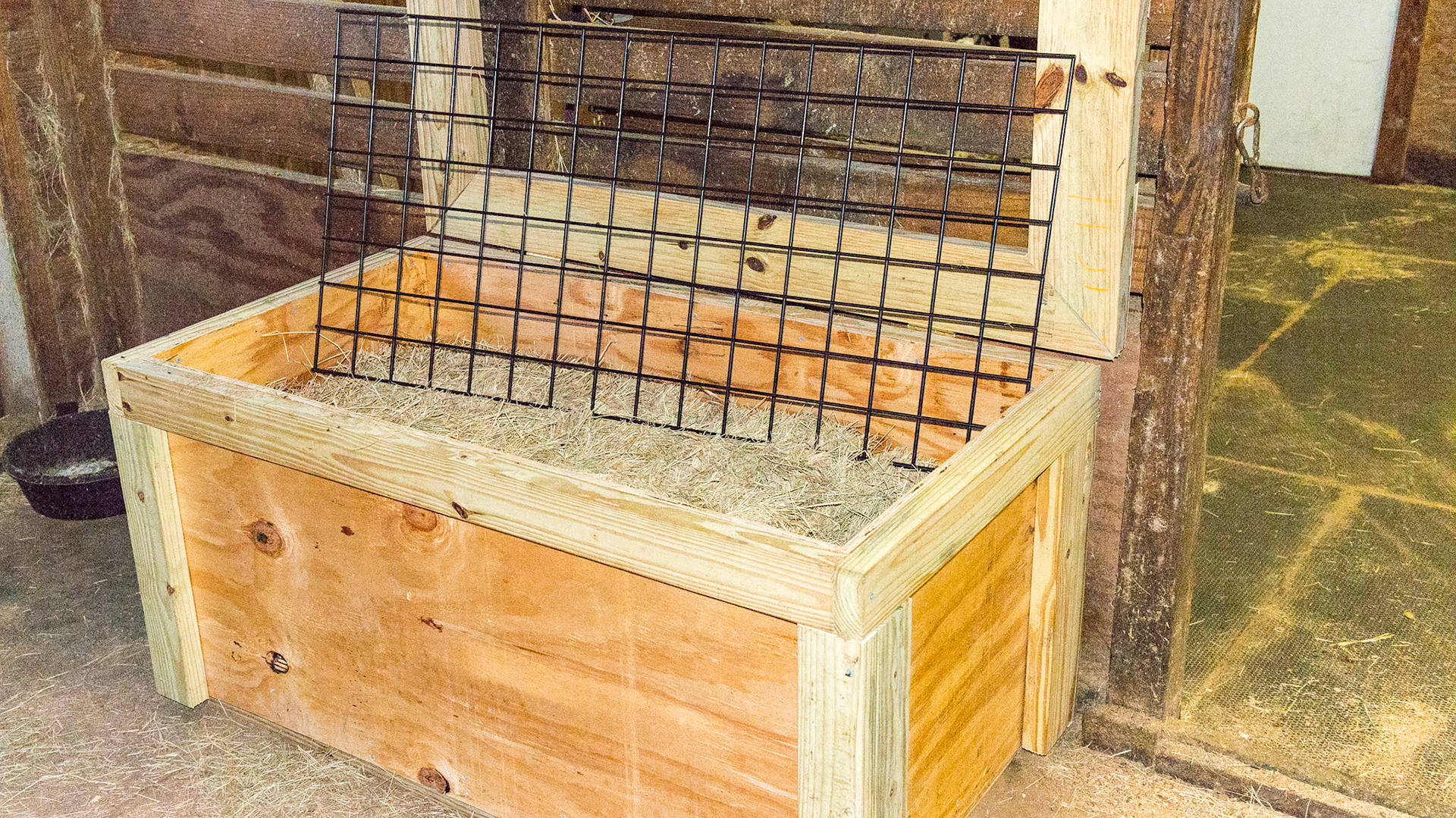 "Slow Grazer" hand built by the owner of this barn. This is day one of its' use.  A floating wire grid on top of the bale slows down the rate of consumption of hay.