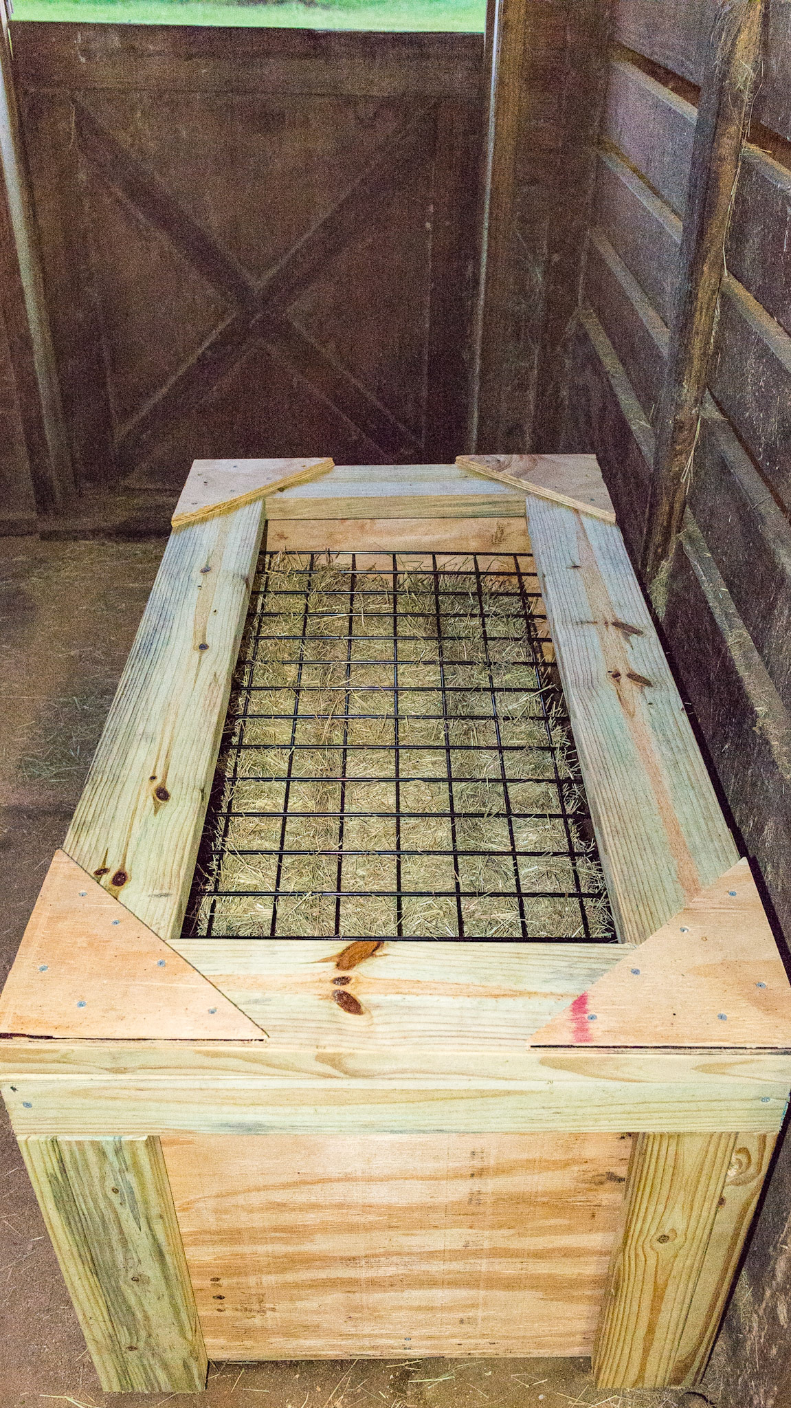 "Slow Grazer" hand built by the owner of this barn. This is day one of its' use.  A floating wire grid on top of the bale slows down the rate of consumption of hay.