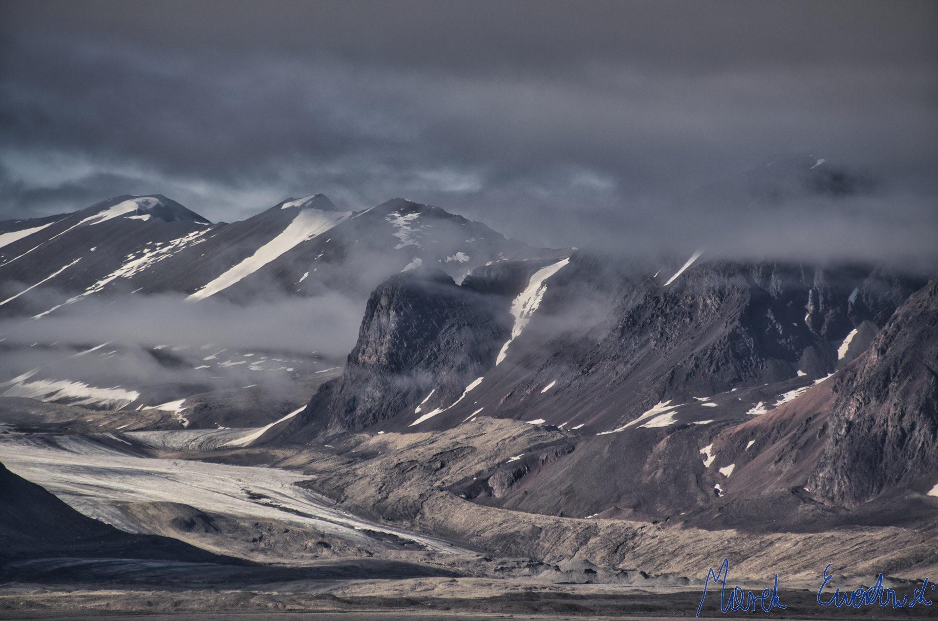 100 years ago the ice surface reached tops of the bright-coloured lateral moraines. Nowadays the glacier is rapidly decaying and retreating. Hørbyebreen, Svalbard.