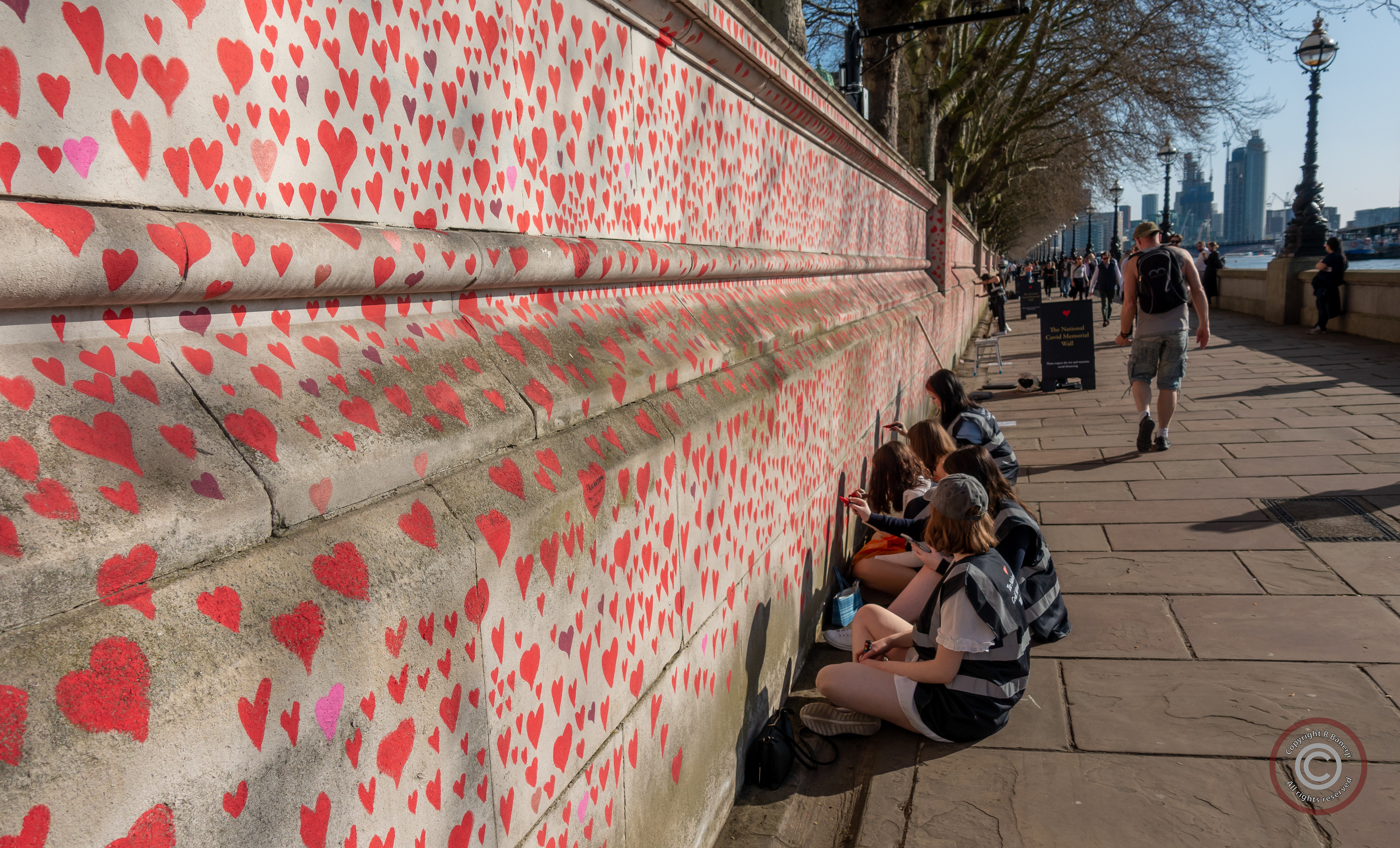 Volunteers paint red hearts on the National Covid Memorial Wall, Westminster, London