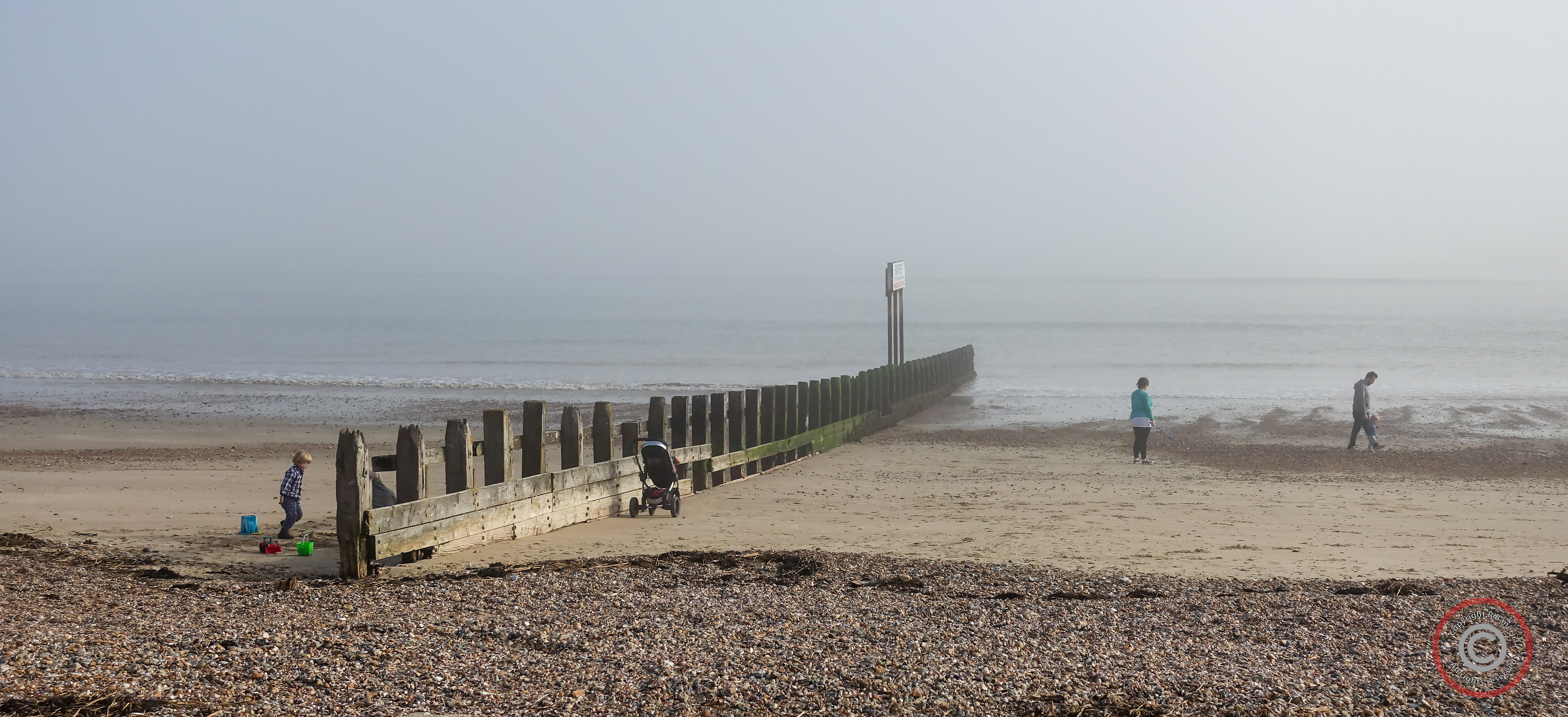 Playing by a misty seaside, Worthing, England