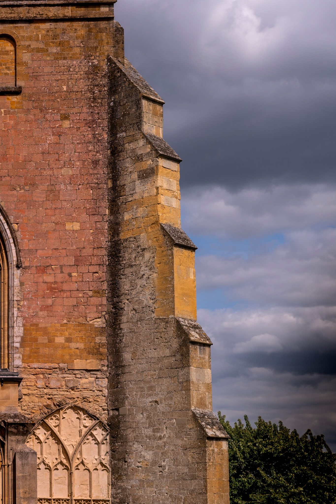 Storm Approaching: The brickwork of Tewkesbury Abbey highlighted against a darkening sky. Portrait. Colour. Printed on EpsonArchivalMatte