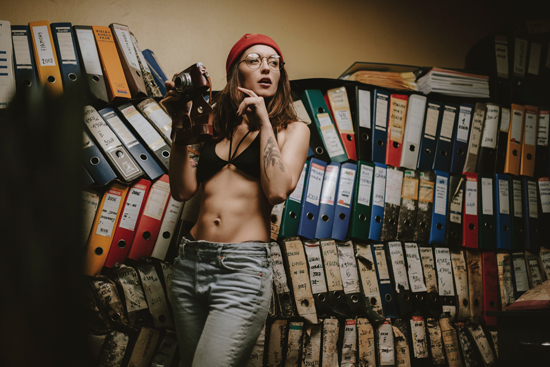 fotografia portretowa, sesja zdjęciowa, stary magazyn, hipsterka, kobieta w okularach trzymająca aparat