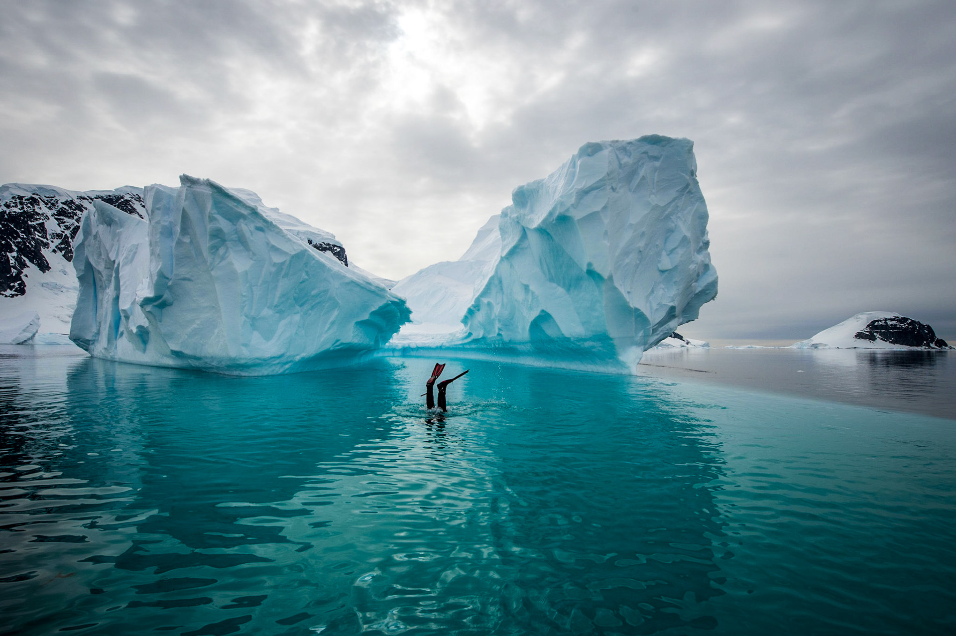 Snorklers approach an iceberg near Danco Island, Antarctica