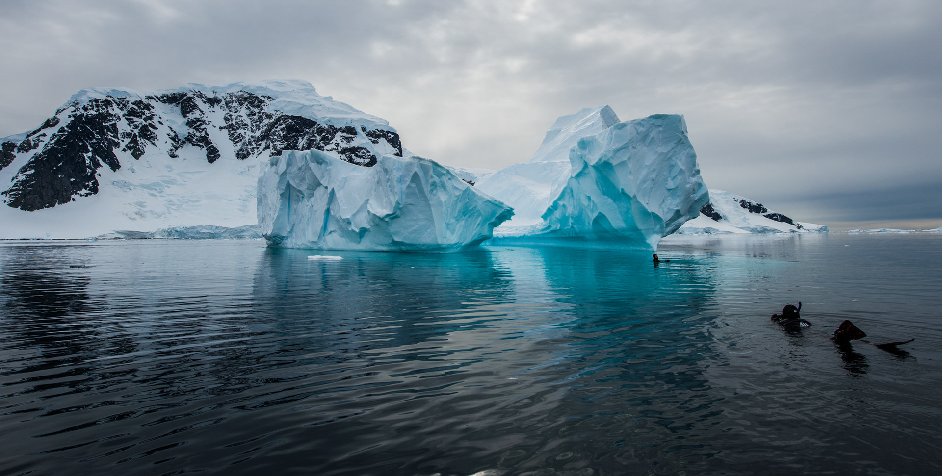 Snorklers approach an iceberg near Danco Island, Antarctica