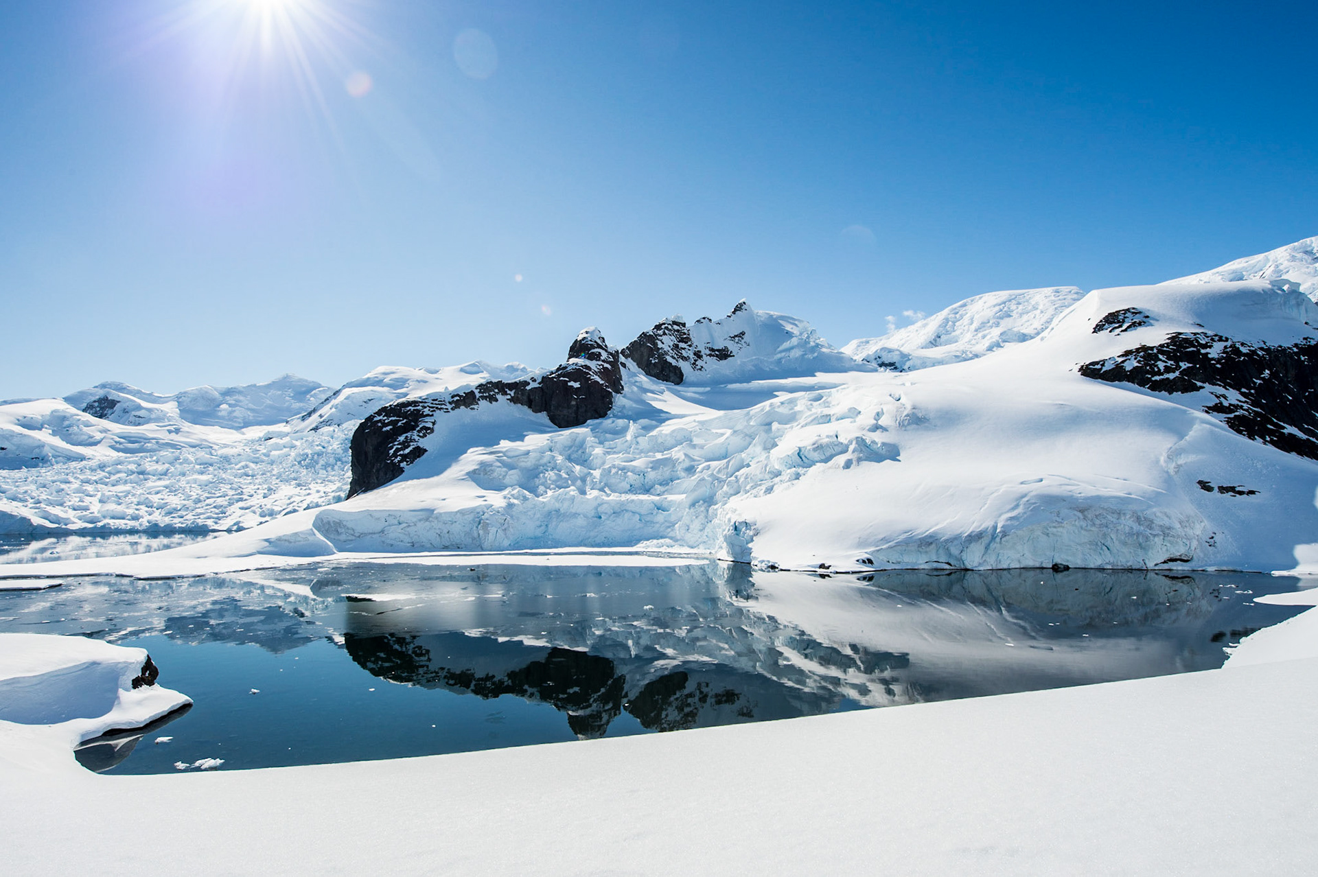 Snow covered mountains reflect in the water, Antarctica