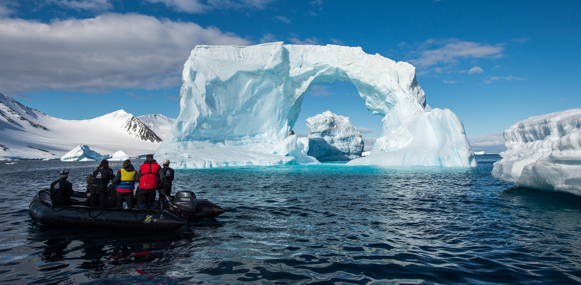 Zodiac near an iceberg arch, near Astrolabe Island, Antarctica