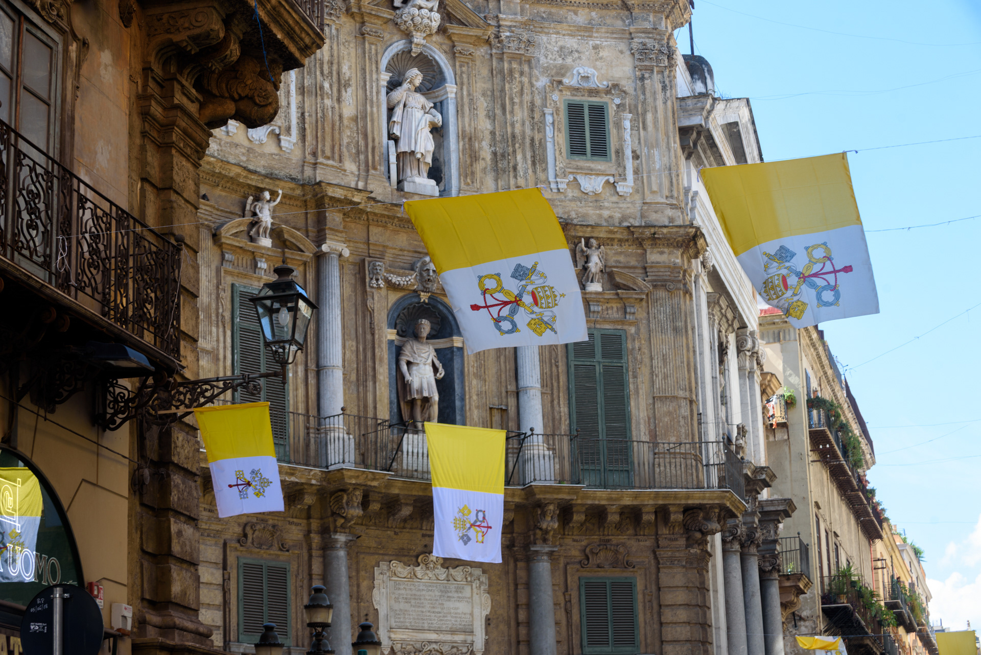Piazza Vigliena, meglio conosciuta come “I Quattro Canti”, cuore simbolico di Palermo all’incrocio tra i due assi viari storici della città: via Maqueda, parallela al profilo del mare, e corso Vittorio Emanuele (il Cassaro), che collega Porta Nuova a monte con Porta Felice sul mare. In questa immagine, la piazza è addobbata con gli stemmi papali in occasione della visita di Papa Francesco, nel XXV del martirio di Padre Pino Puglisi. Palermo, 15/09/2018.