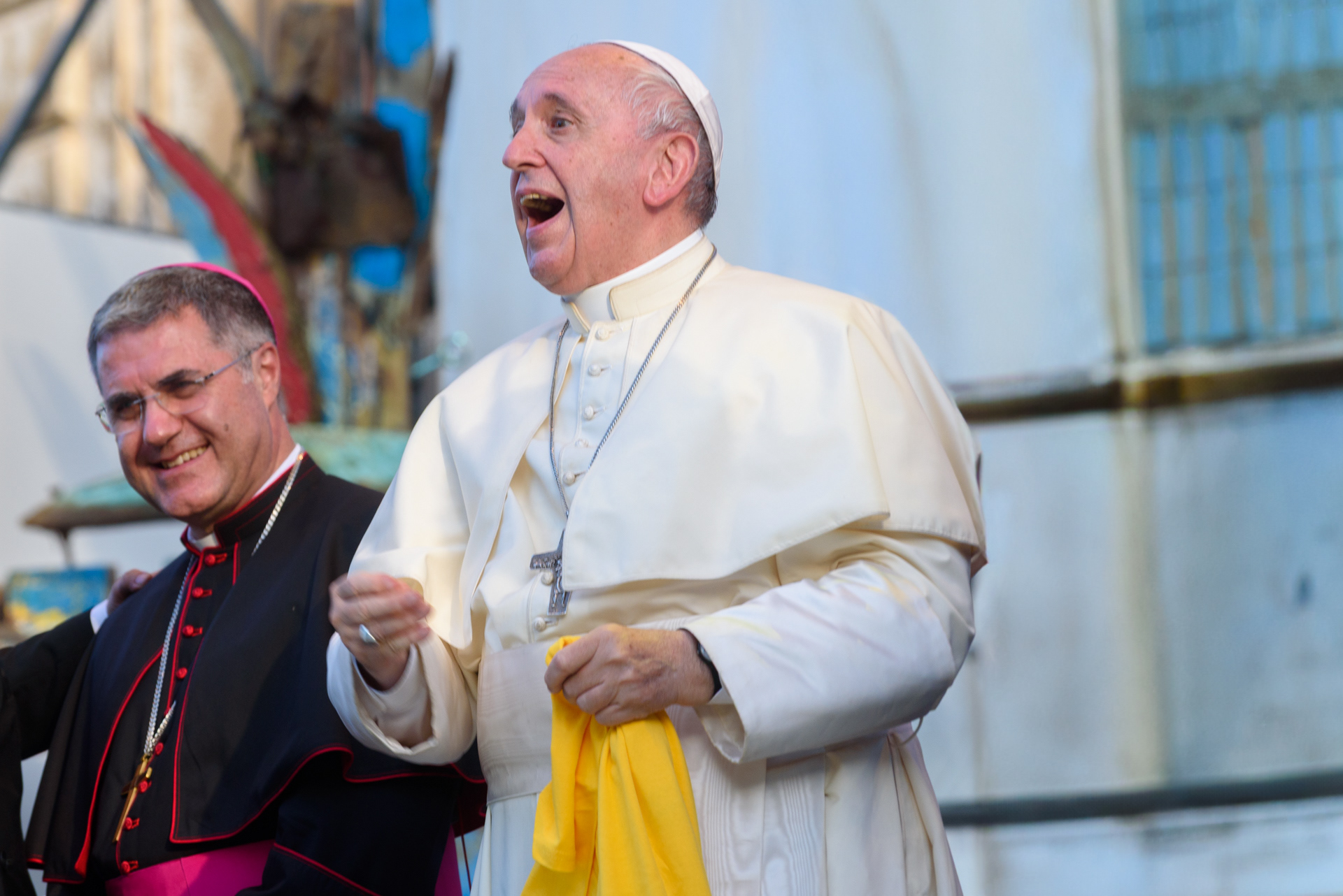 L’atteggiamento gioviale che ha contraddistinto Papa Francesco, rivolto ai pellegrini accorsi in piazza Castelnuovo a Palermo, dal palco allestito, in occasione sua visita alla città, nel XXV del martirio di Padre Pino Puglisi. Alla destra del Papa, l’Arcivescovo Corrado Lorefice mentre sorride partecipe. Palermo, 15/09/2018.