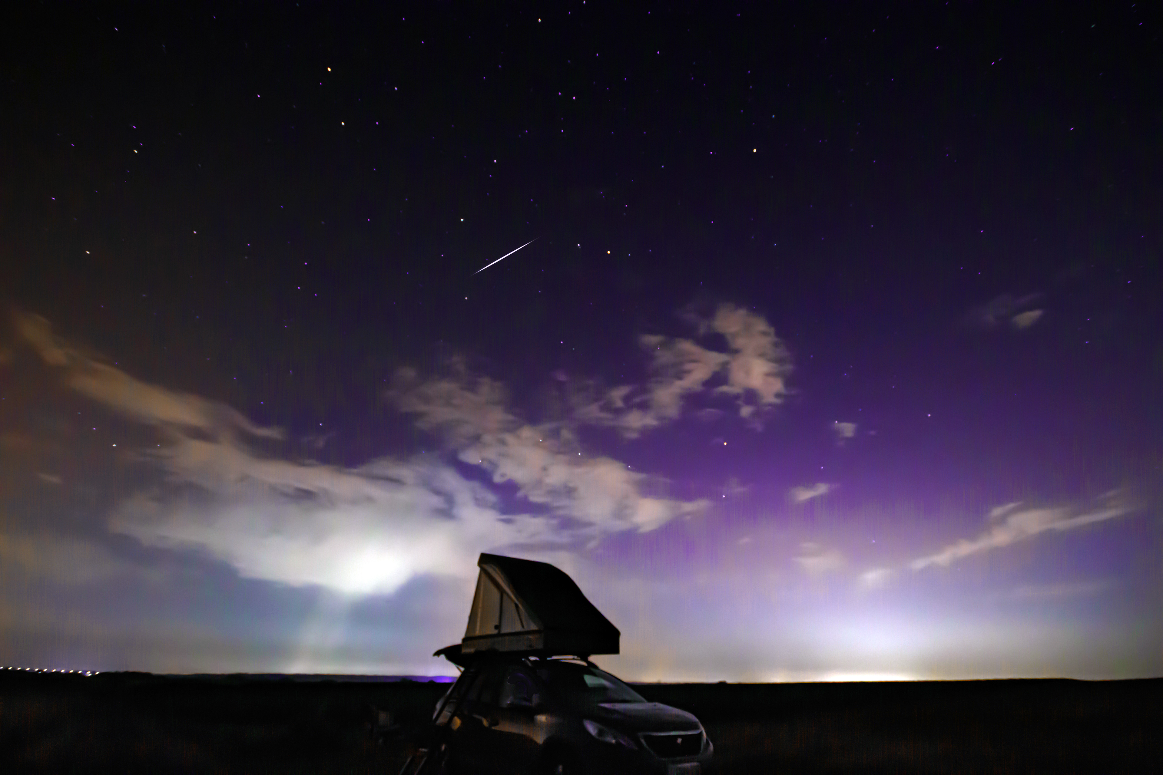 une météorite traverse l'éclat magique d'une aurore boréale.
