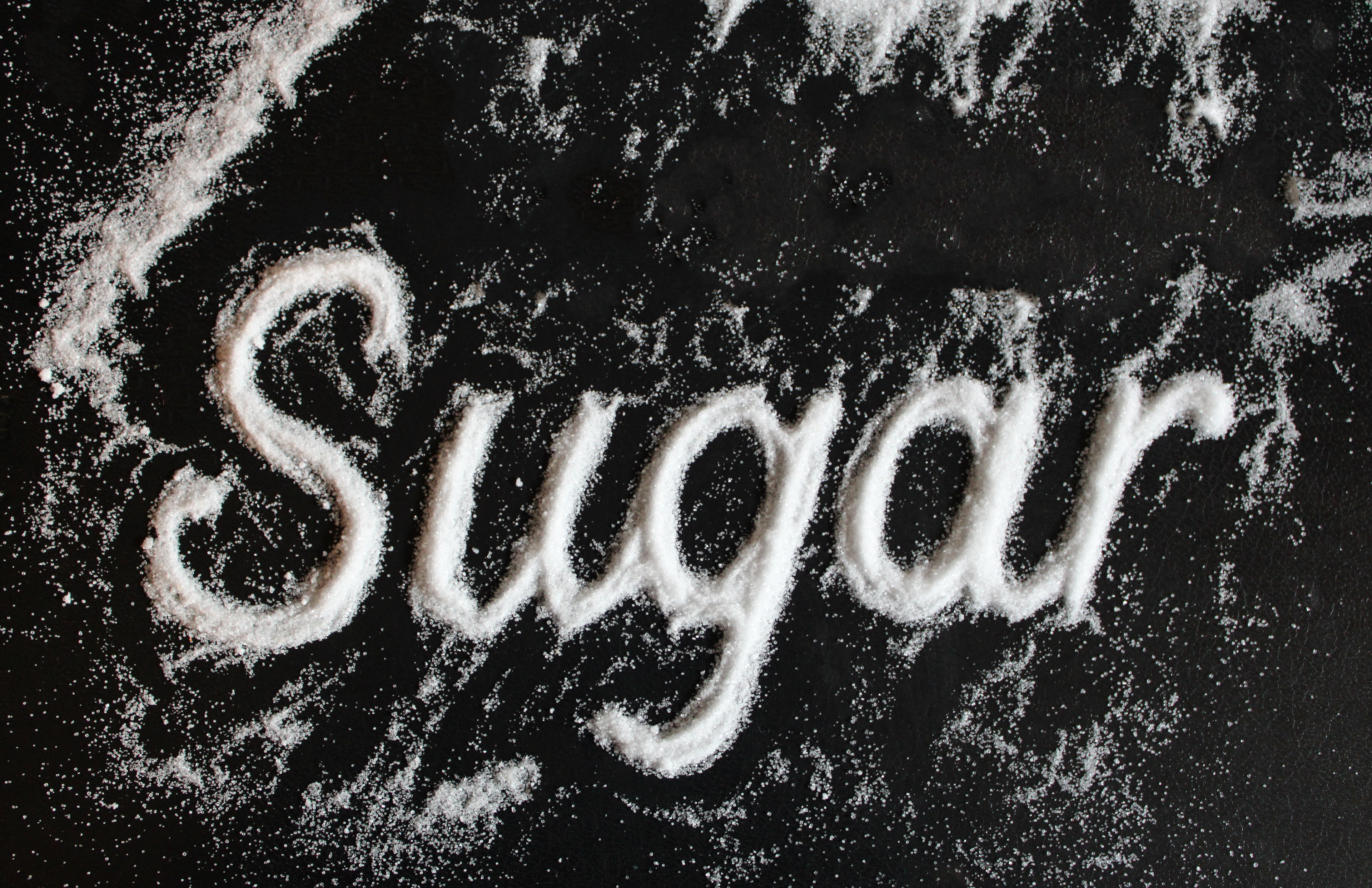 Title: Sugar Description: Sugar sprinkled through text cutout against black sketchbook Date: Fall 2024 Credits: Photography by Luisa F. Ligardo