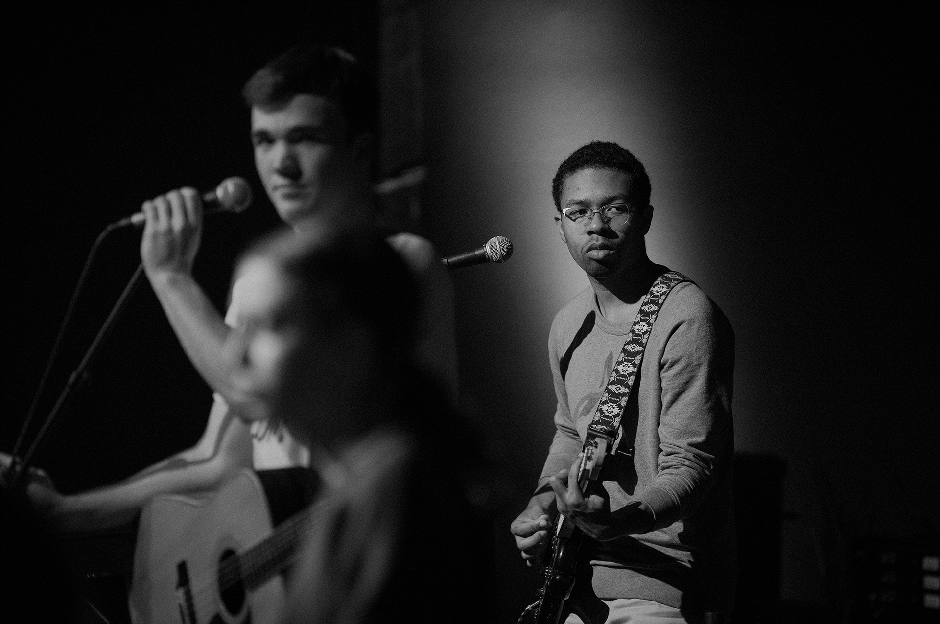 Seniors in high school, Cole Christensen (left) and Jacques Armstrong (right), pause during an after-school rehearsal to listen to another worship team member's suggestions.