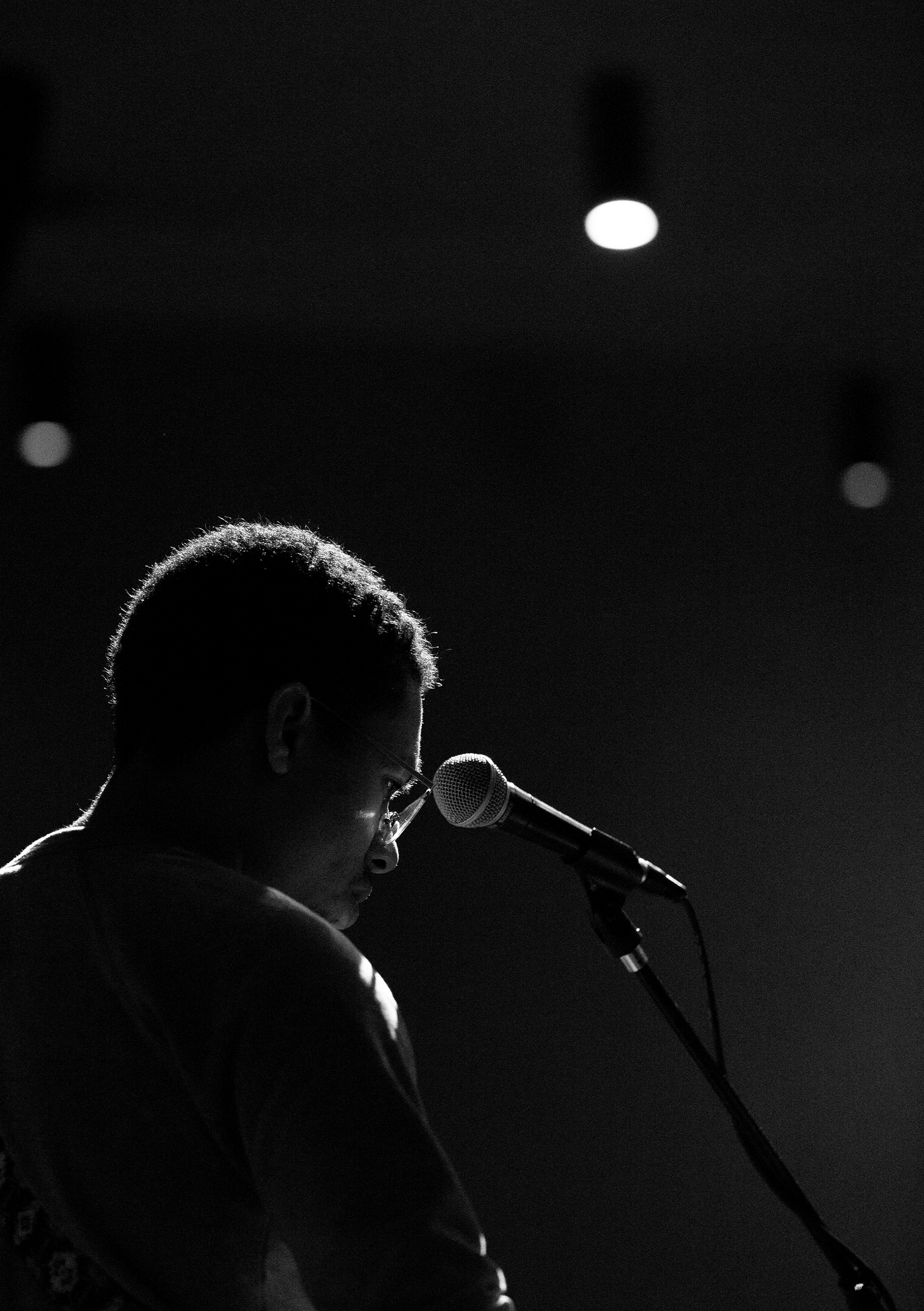 High schooler, bassist, and vocalist, Jacques Armstrong, focuses on his sheet music during a Friday evening rehearsal.