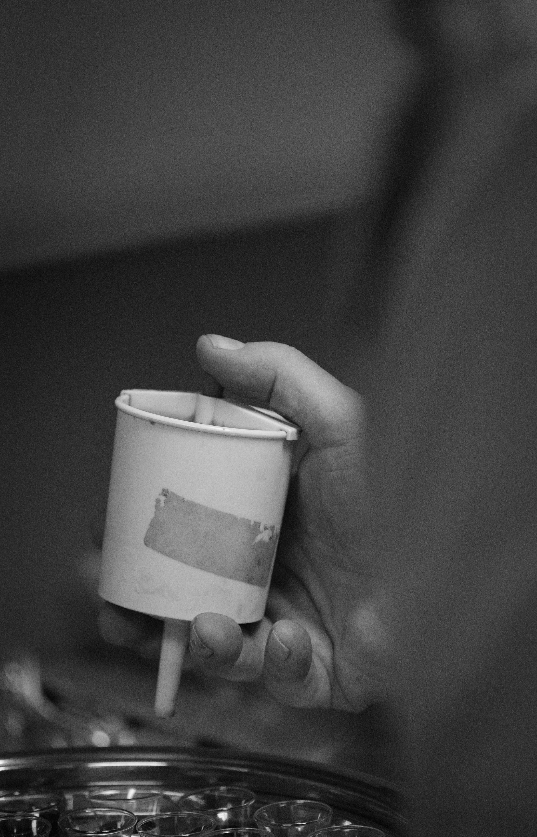 To fill up the cups, John uses a small handheld contraption. A newer version is available in a drawer nearby, but he prefers the slower pace at which the juice comes out in the older one.