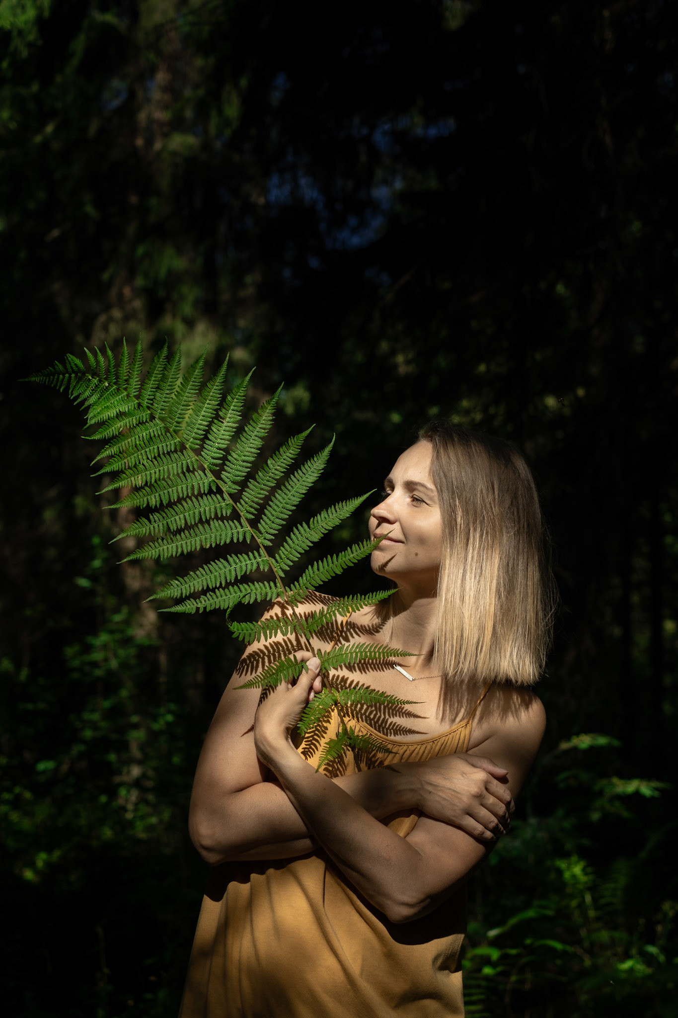 portreefoto naisest, sõnajalaga, metsa taust