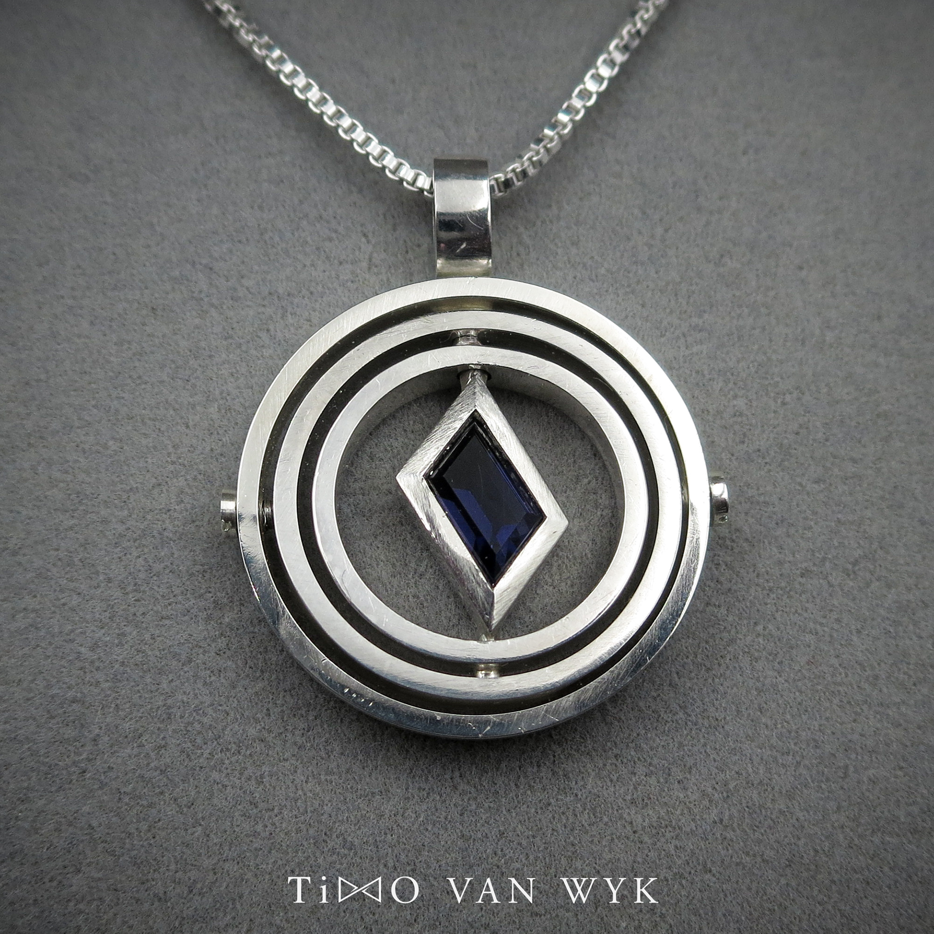 kinetic pendant made from silver with iolite stone inside.