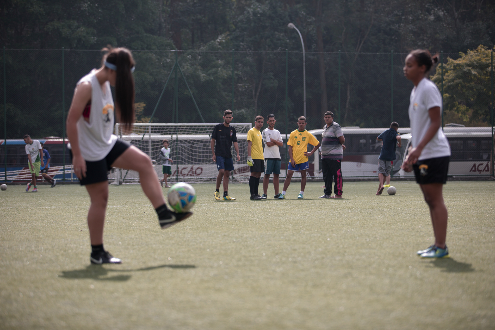 Ana Paula Santos e Thayla Grigório batem bola sob os olhares atentos de meninos no Sesc Itaquera, na zona leste de São Paulo, em julho de 2017