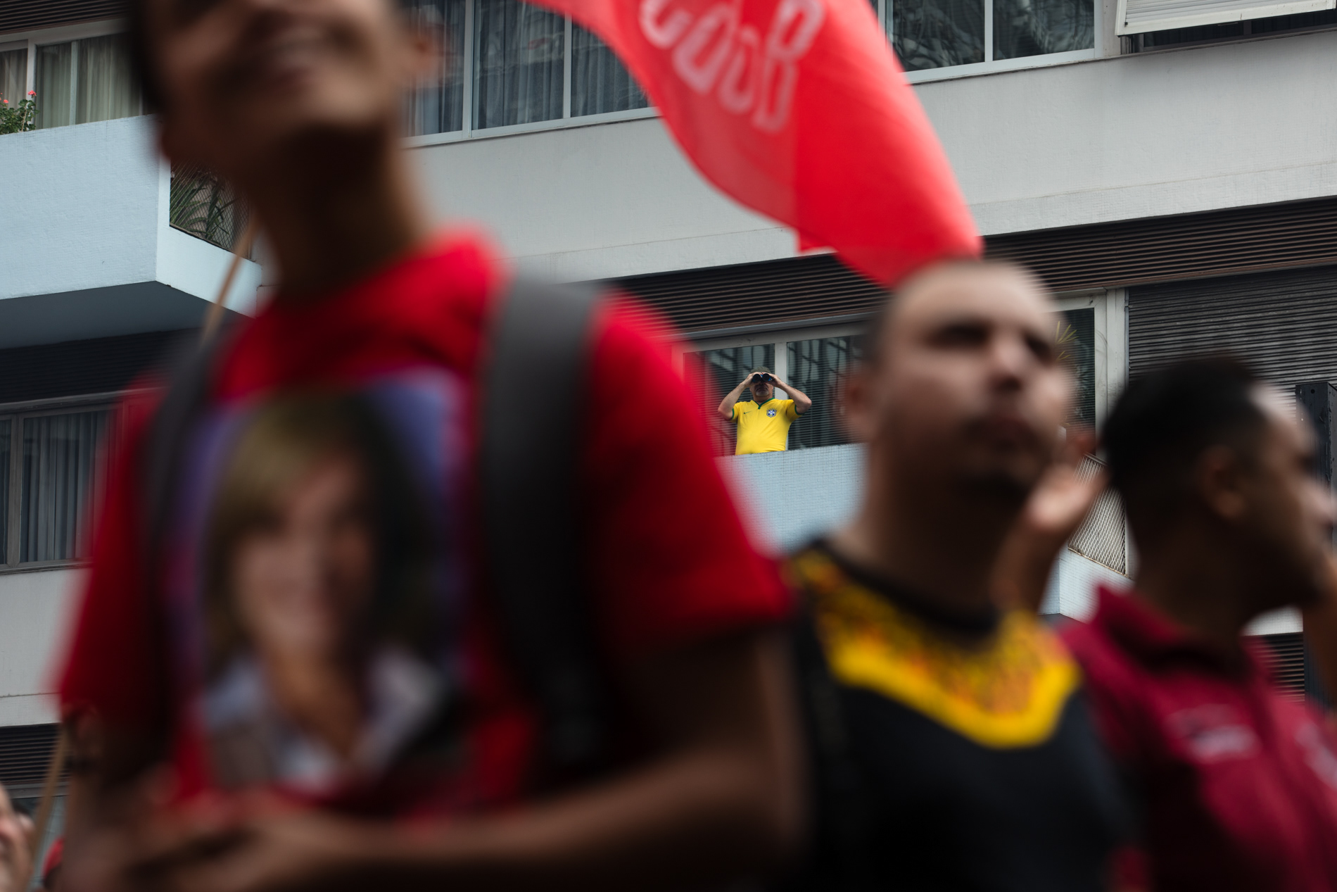 Homem observa protesto da CUT na Avenida Paulista, em São Paulo, durante o Dia do Trabalho