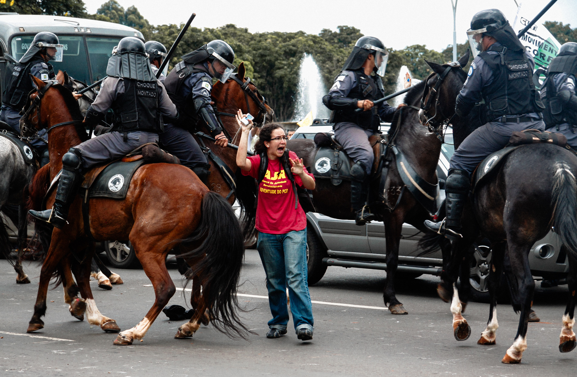 Manifestante se defende de ataque da cavalaria da Polícia Militar do Distrito Federal durante protesto contra o então governador José Roberto Arruda em Brasília, em 2010
