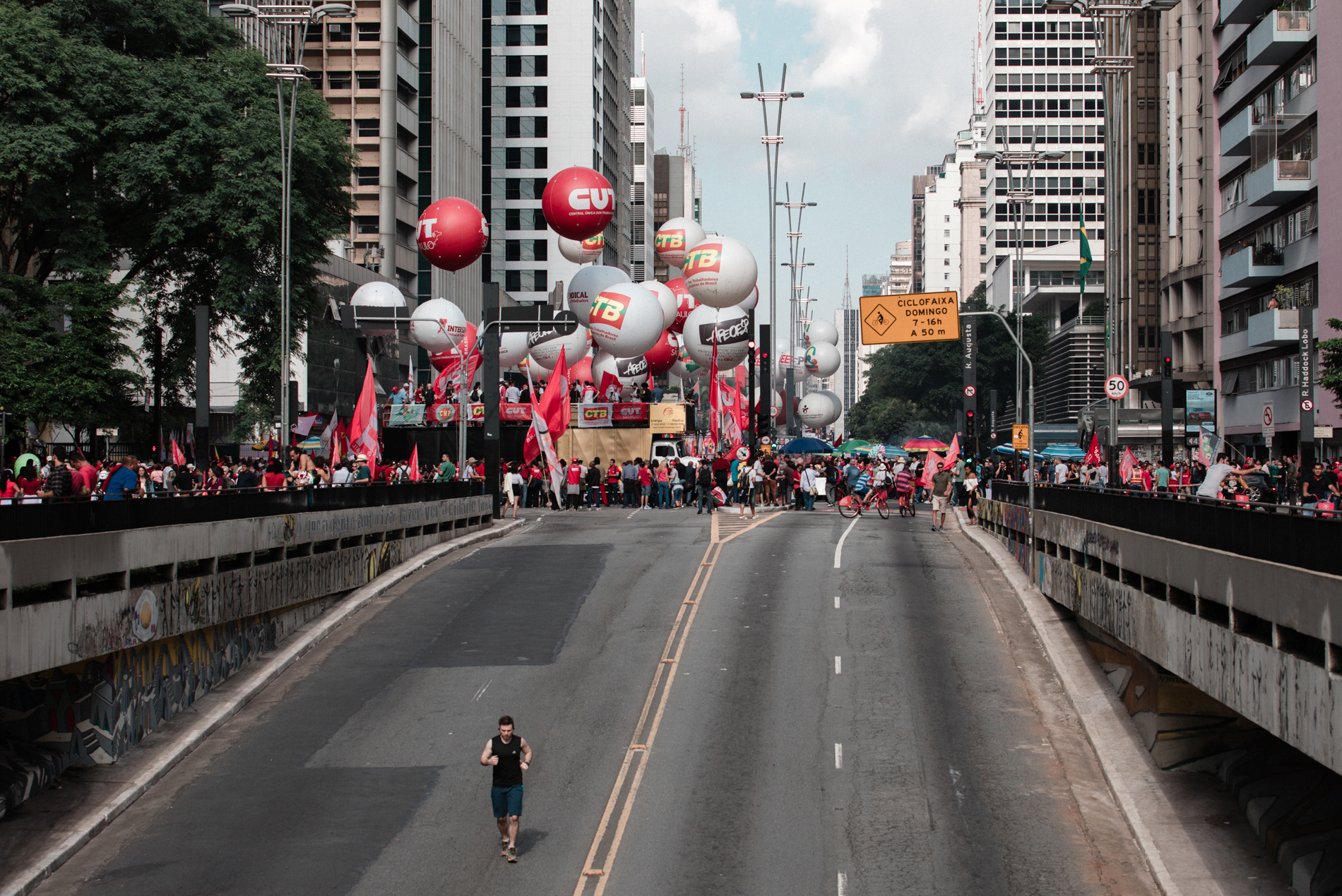 Homem corre na Avenida Paulista, em São Paulo, durante manifestação da Central Única dos Trabalhadores (CUT) pelo dia do trabalho, em maio de 2017