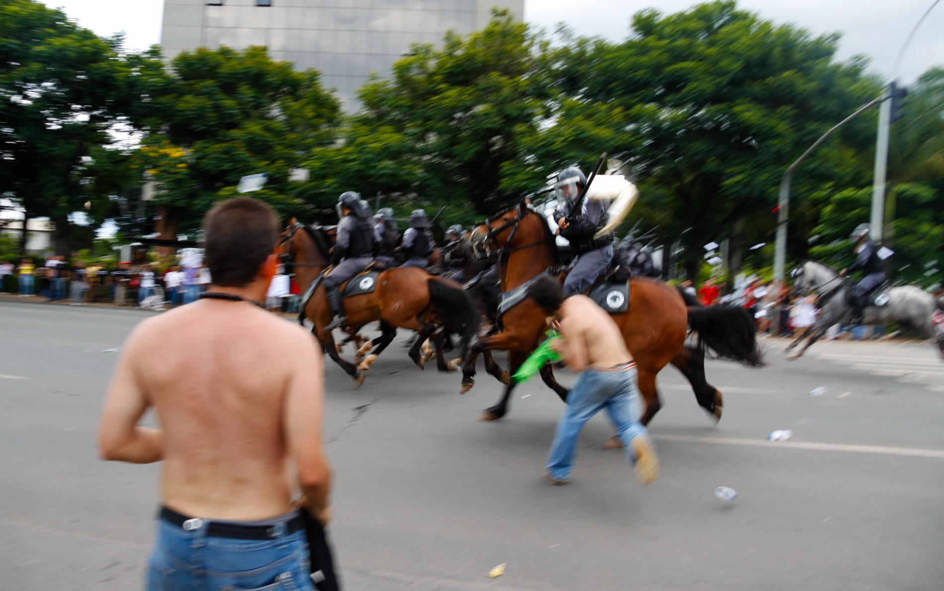 Manifestante atira um objeto contra a cavalaria da Polícia Militar do Distrito Federal durante protesto contra o então governador José Roberto Arruda em Brasília, em 2010