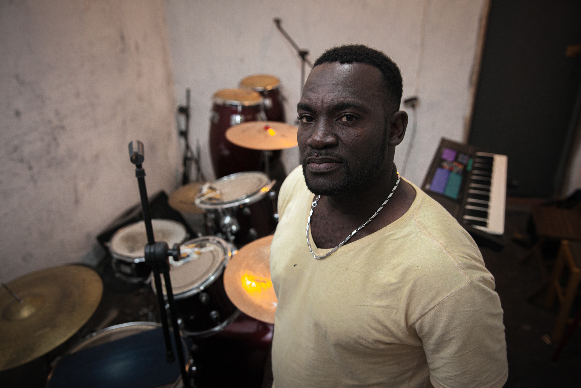 O haitiano Louides Charles posa para foto, em junho de 2016, em um estúdio improvisado em uma ocupação no centro de São Paulo onde sua banda Satelite ensaia. Ele trabalha na construção civil no Brasil e fundou uma banda que toca músicas de seu país