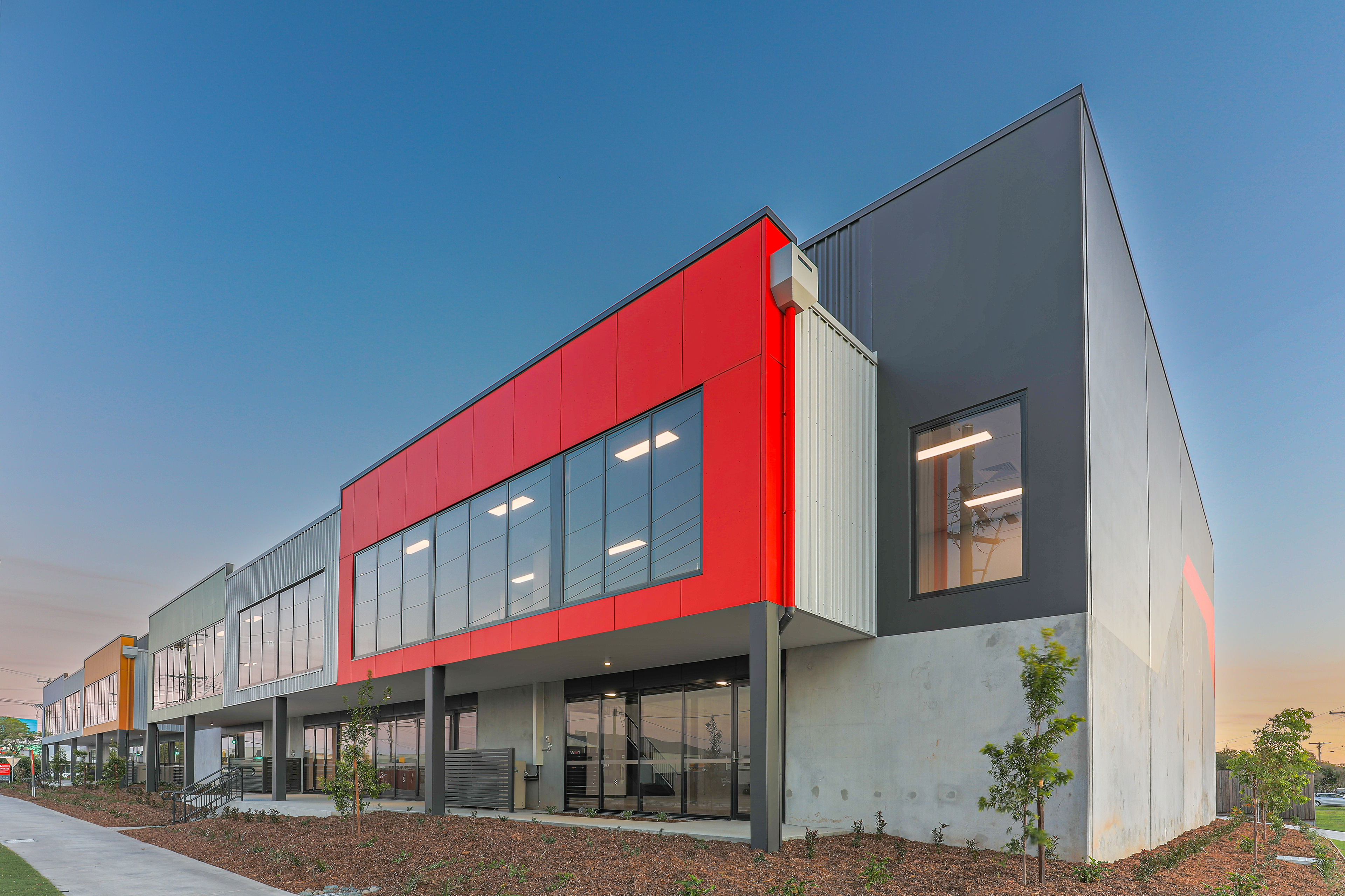 Modern commercial building with colorful exterior design, large windows, and landscaped surroundings, located in Ipswich, QLD. Professional commercial photography by Jeremy Murphy.
