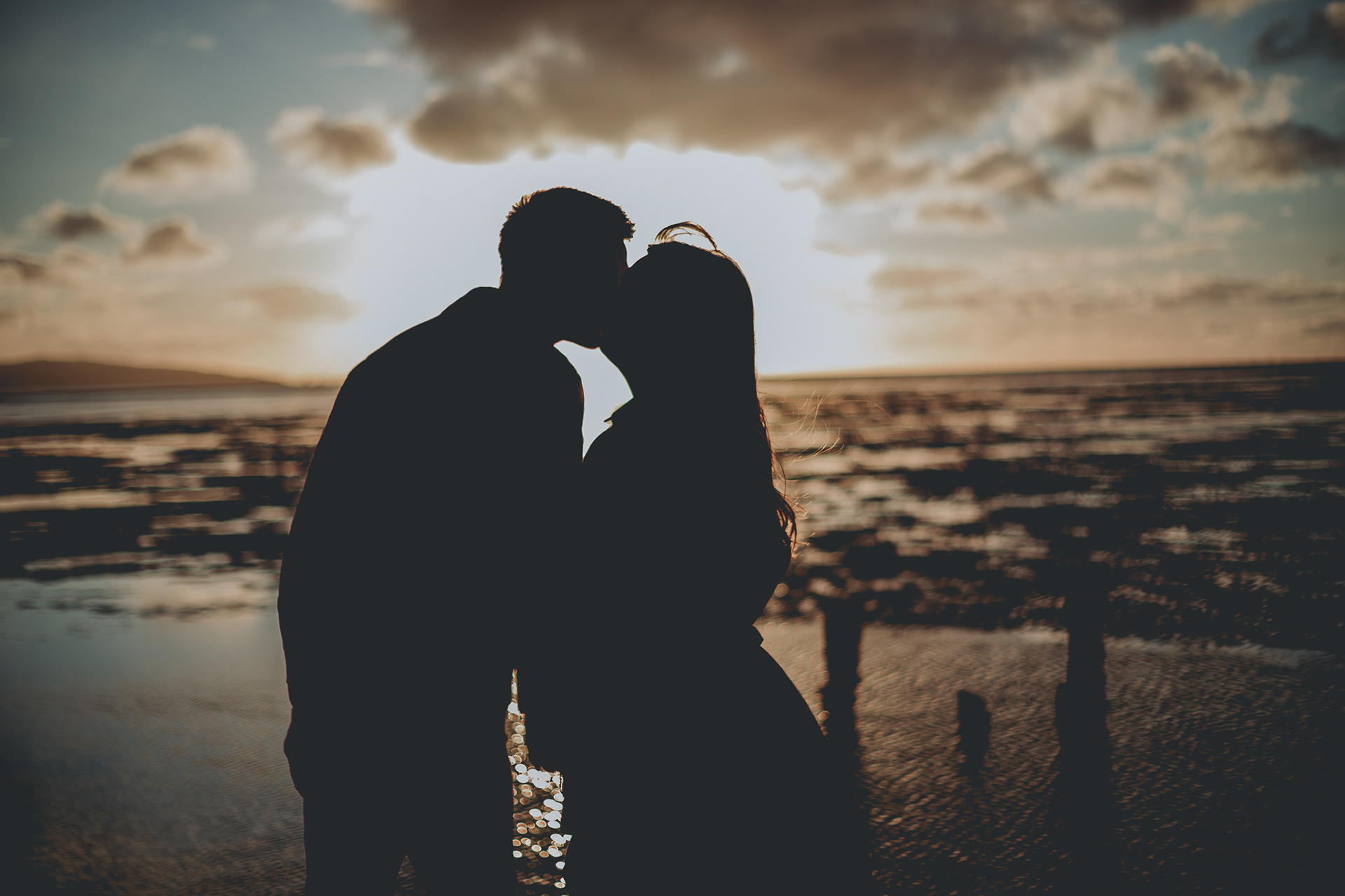 couples pre-wedding shoot on beach at sunset kiss
