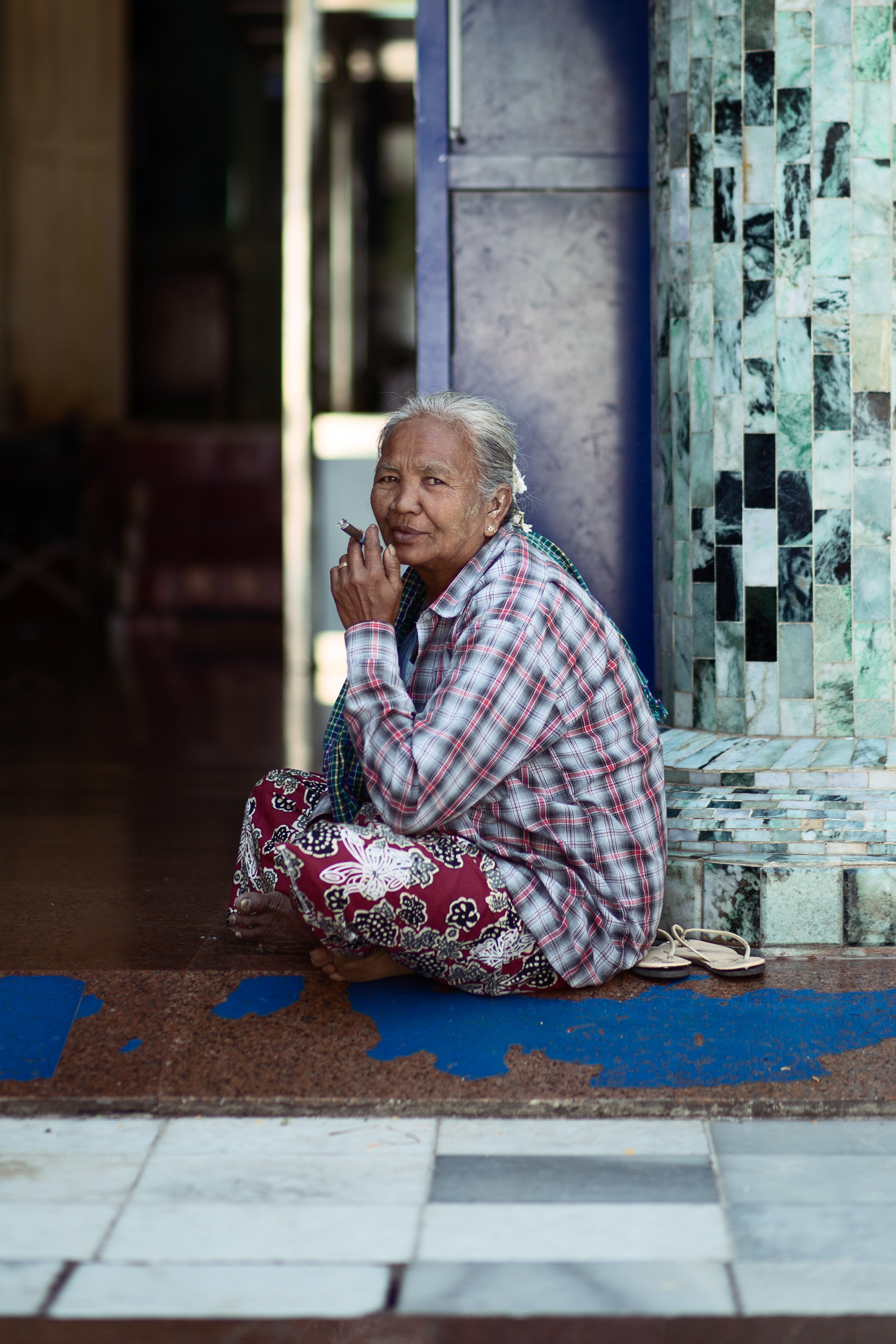 Portrait of a Burmese woman sitting in the Mahamuni Pagoda
