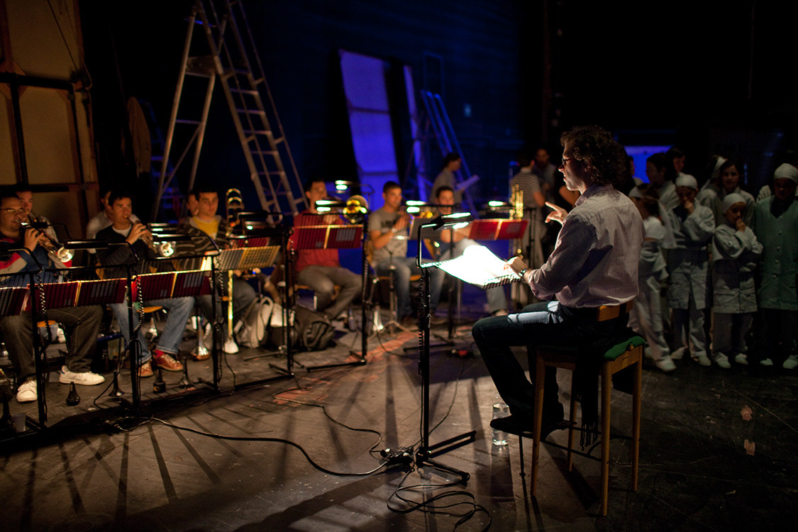 Santiago Serrate, conducting musicians behind the stage